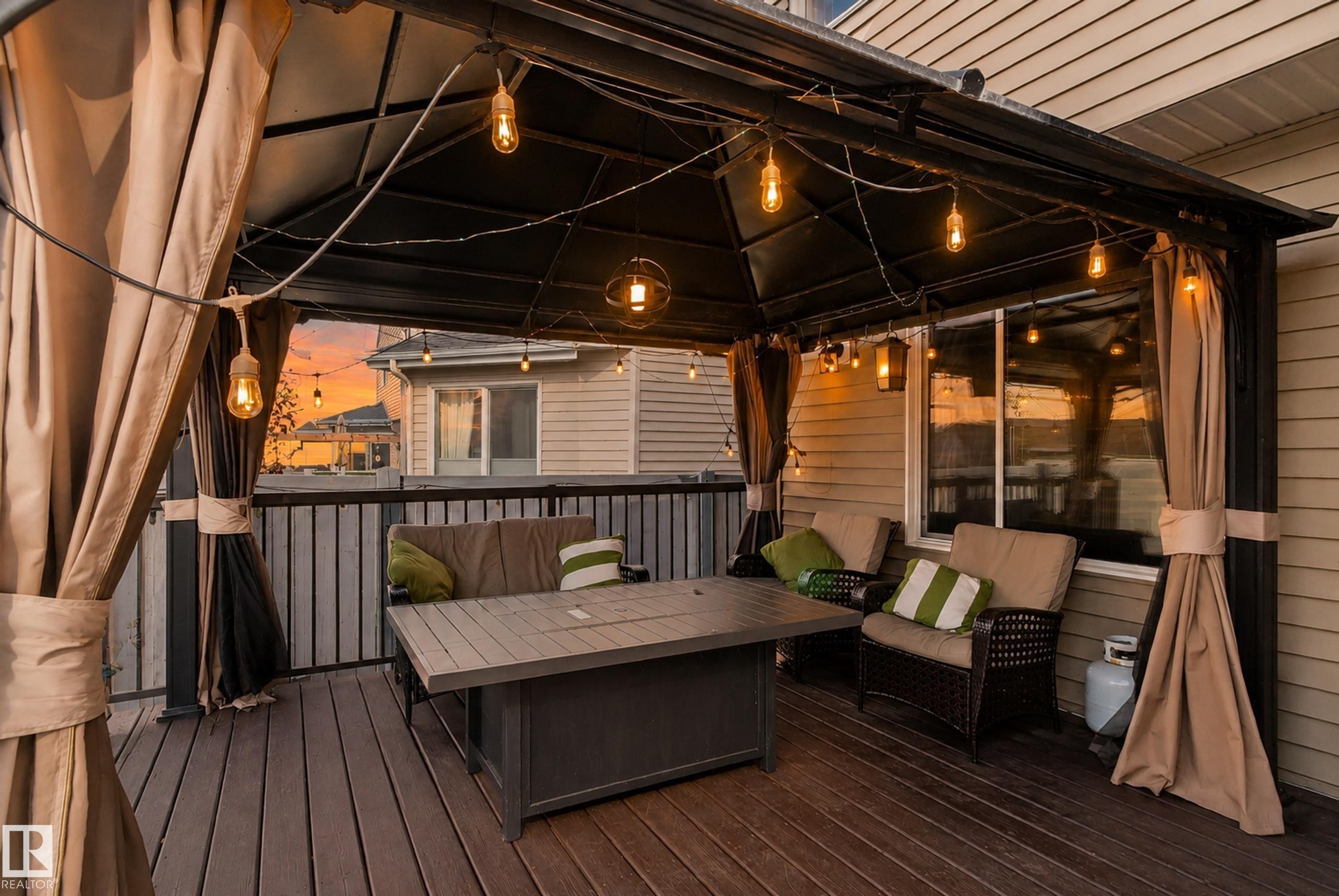 Private outdoor deck with composite decking, a permanent gazebo structure, and integrated string lighting - 1332 72 Street Sw, Edmonton, AB