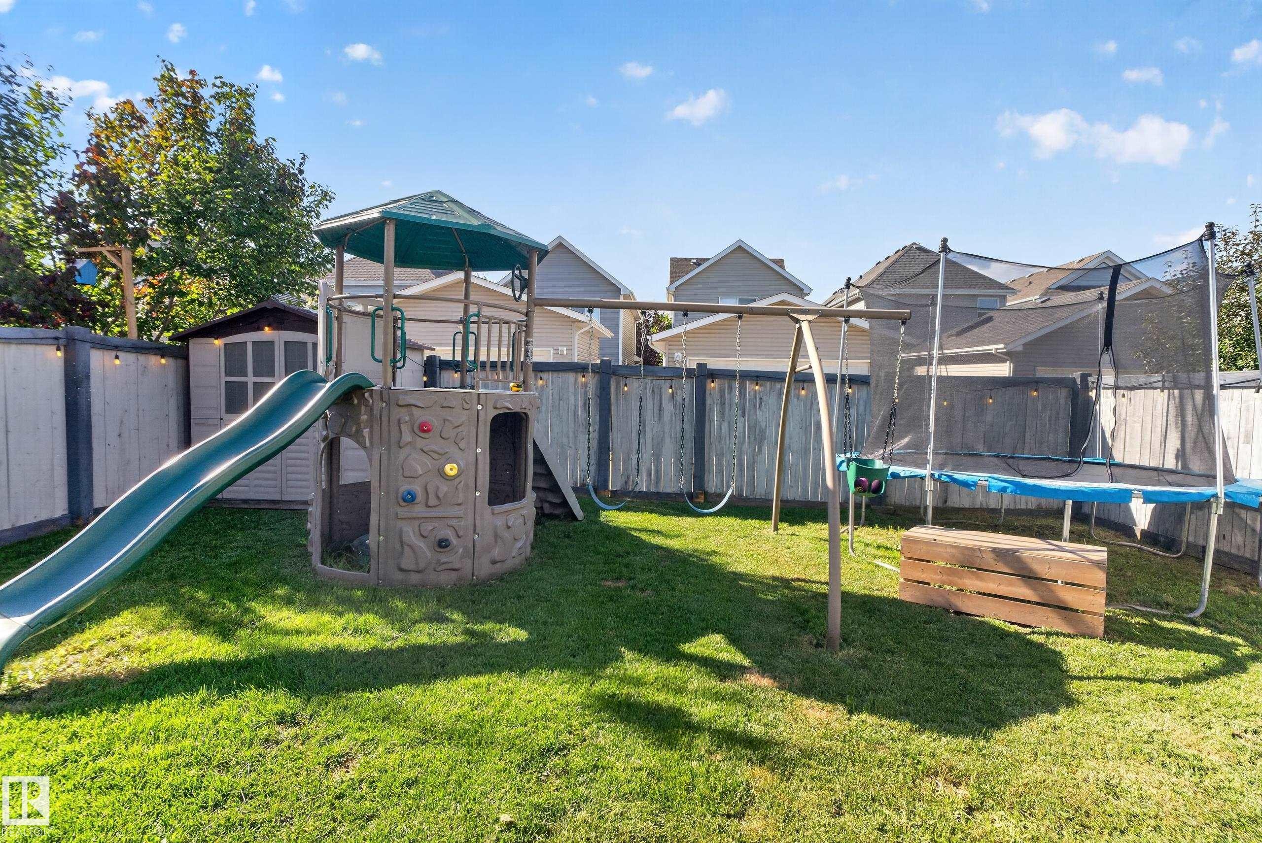 Expansive fenced yard featuring a storage shed and mature perimeter trees - 1332 72 Street Sw, Edmonton, AB