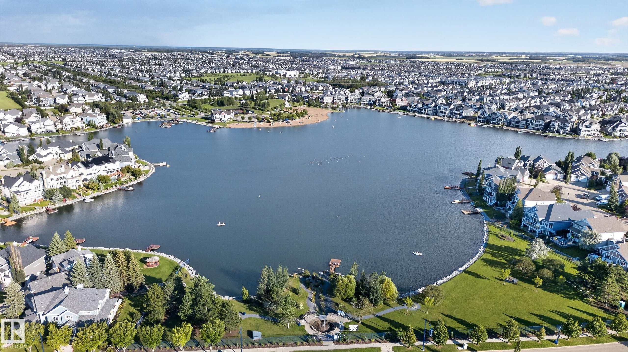 Waterfront residences with private docks, a sandy beach area, and expansive green spaces - 1332 72 Street Sw, Edmonton, AB