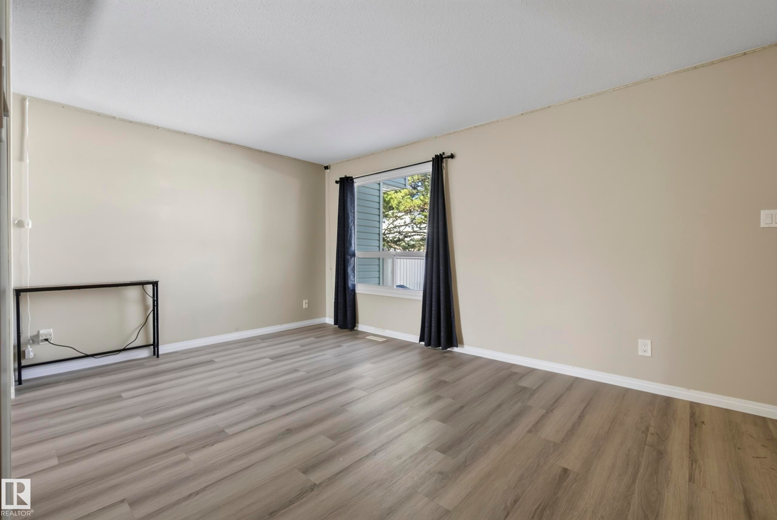 Wood-finish flooring with light-toned wall paint and white trim - 141 Dickinsfield Court Nw, Edmonton, AB
