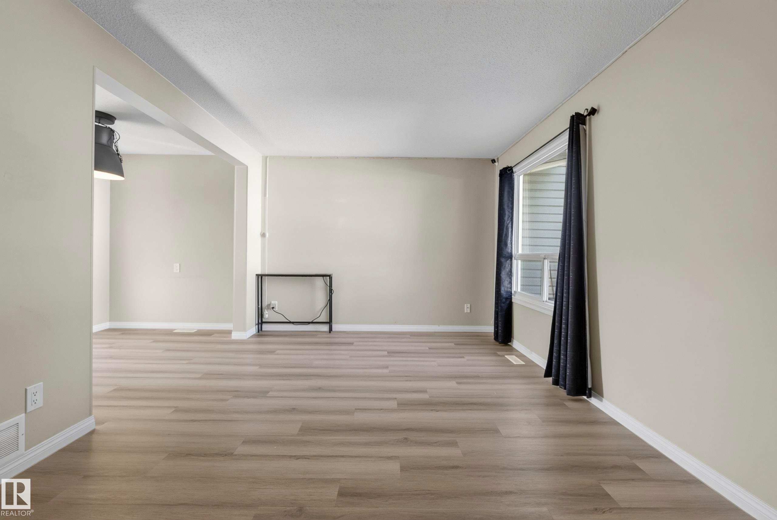 Wood-finish flooring throughout, neutral wall tones, and a window with blinds - 141 Dickinsfield Court Nw, Edmonton, AB