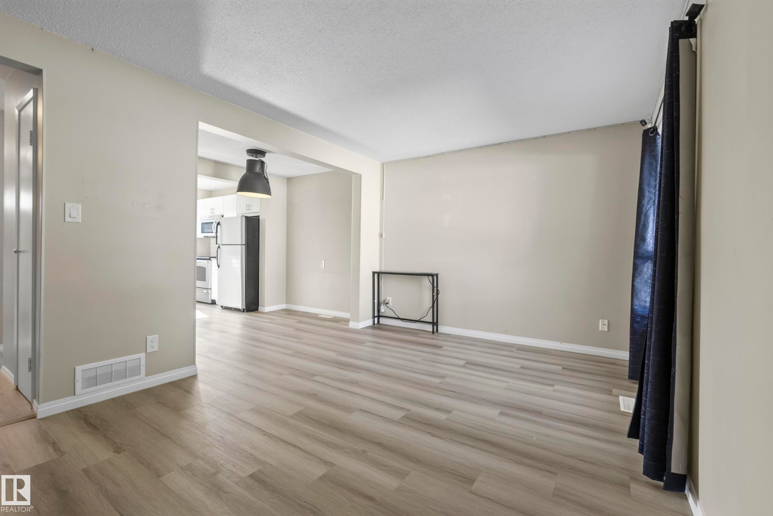 Wood-finish flooring throughout, light neutral wall tones, and recessed ceiling lighting - 141 Dickinsfield Court Nw, Edmonton, AB