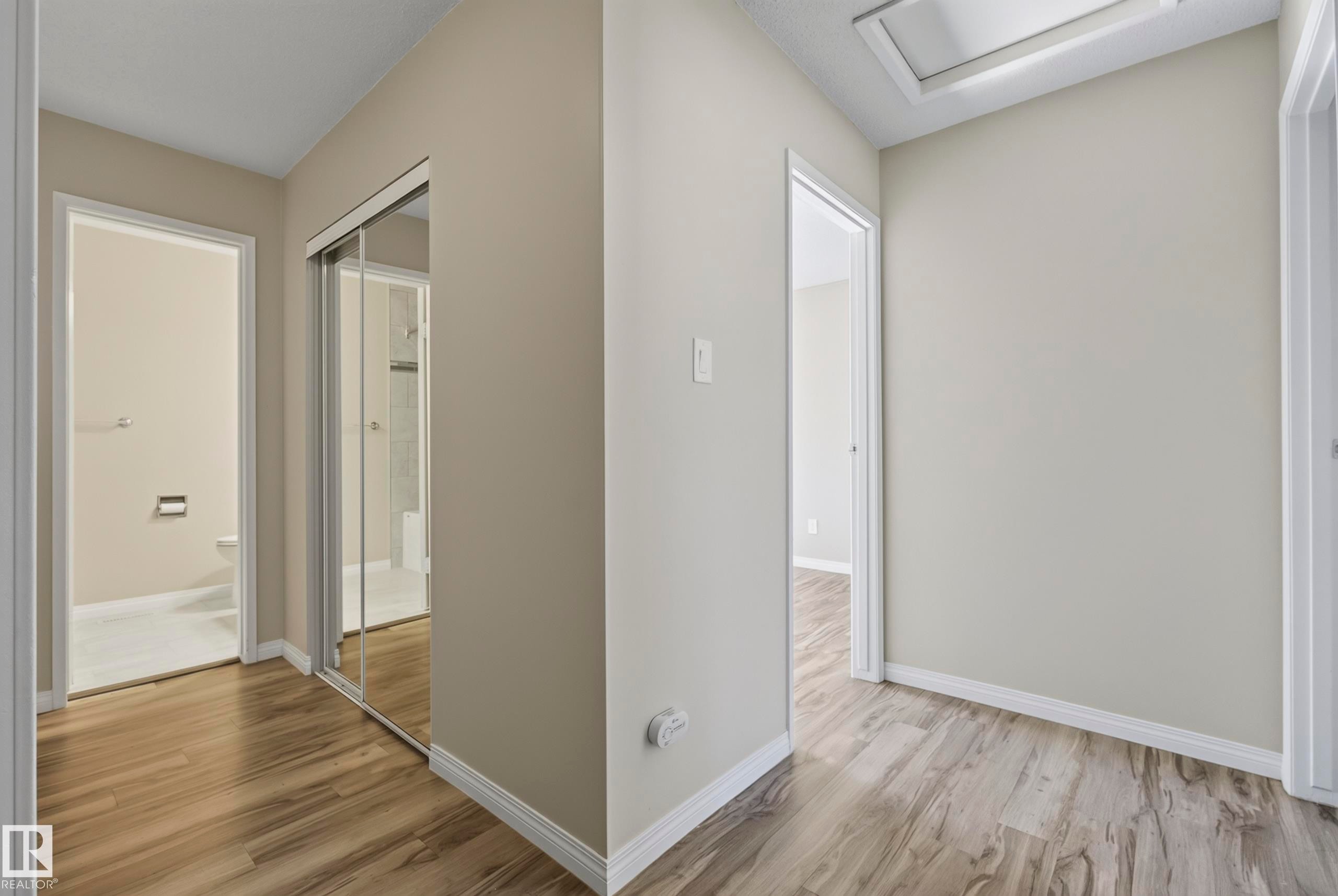 Wood-finish flooring throughout the hall - 141 Dickinsfield Court Nw, Edmonton, AB