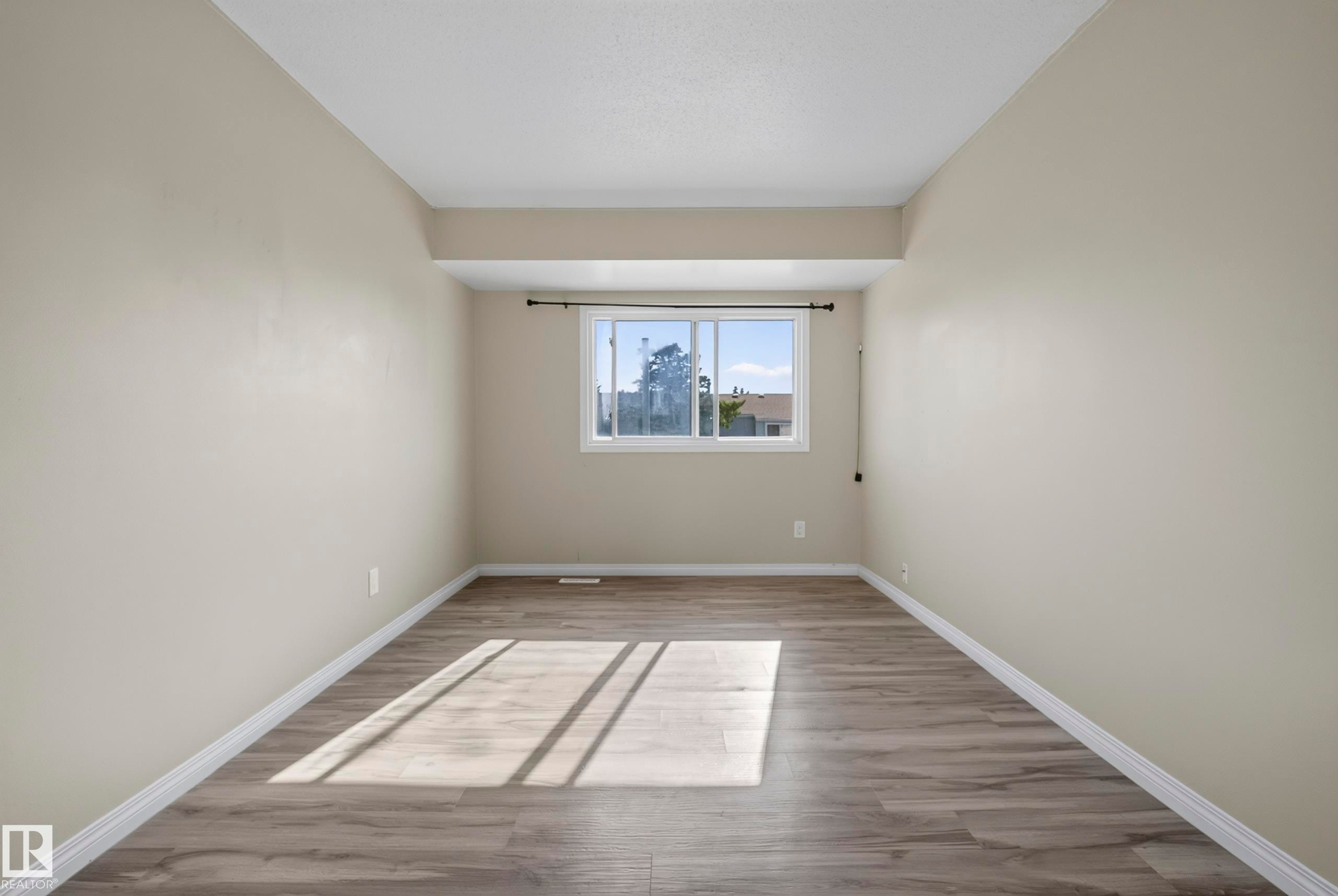 Wood-finish flooring, neutral wall tones, and a white-framed window - 141 Dickinsfield Court Nw, Edmonton, AB