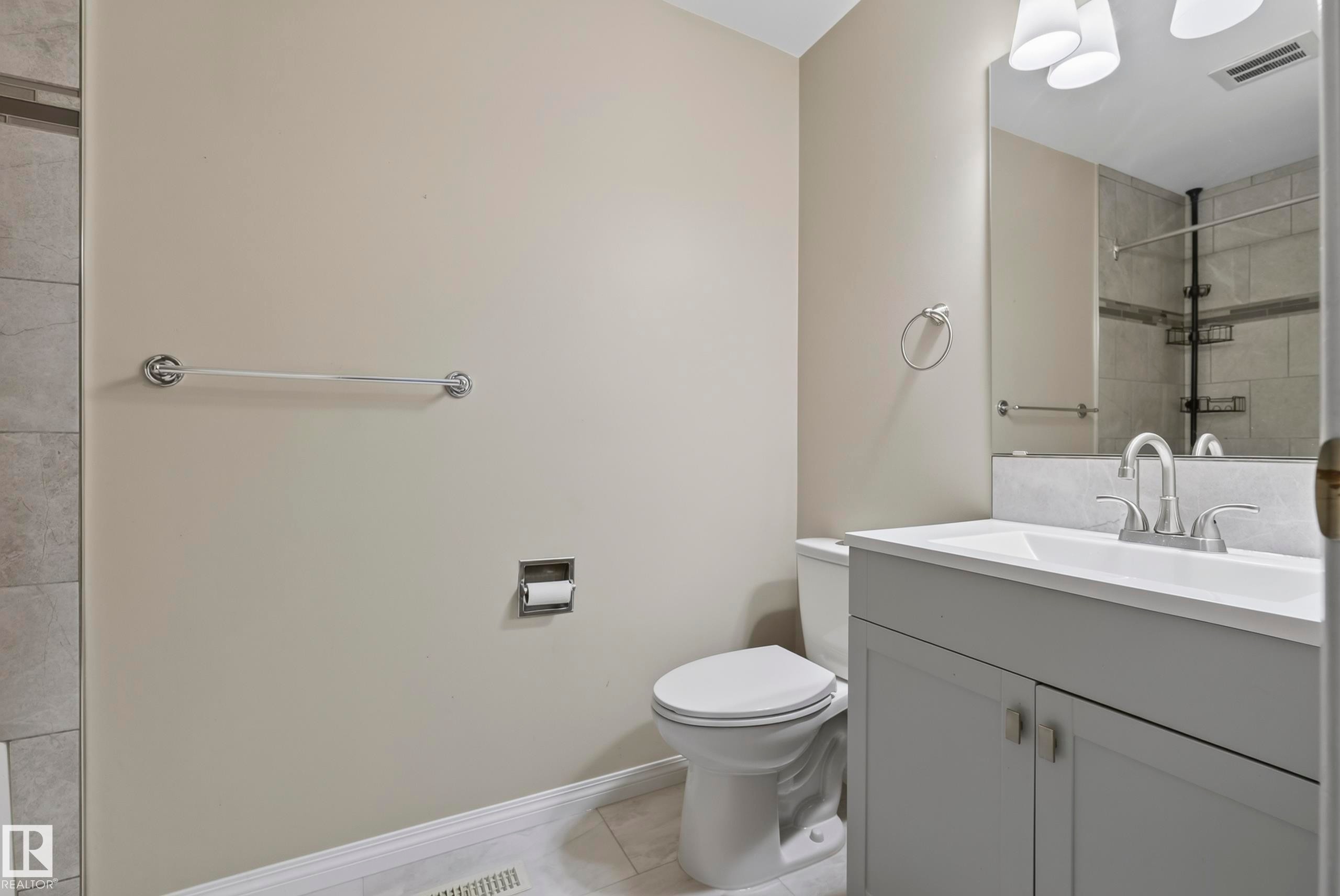 Vanity with an integrated sink, polished chrome faucet, and under-sink cabinetry - 141 Dickinsfield Court Nw, Edmonton, AB
