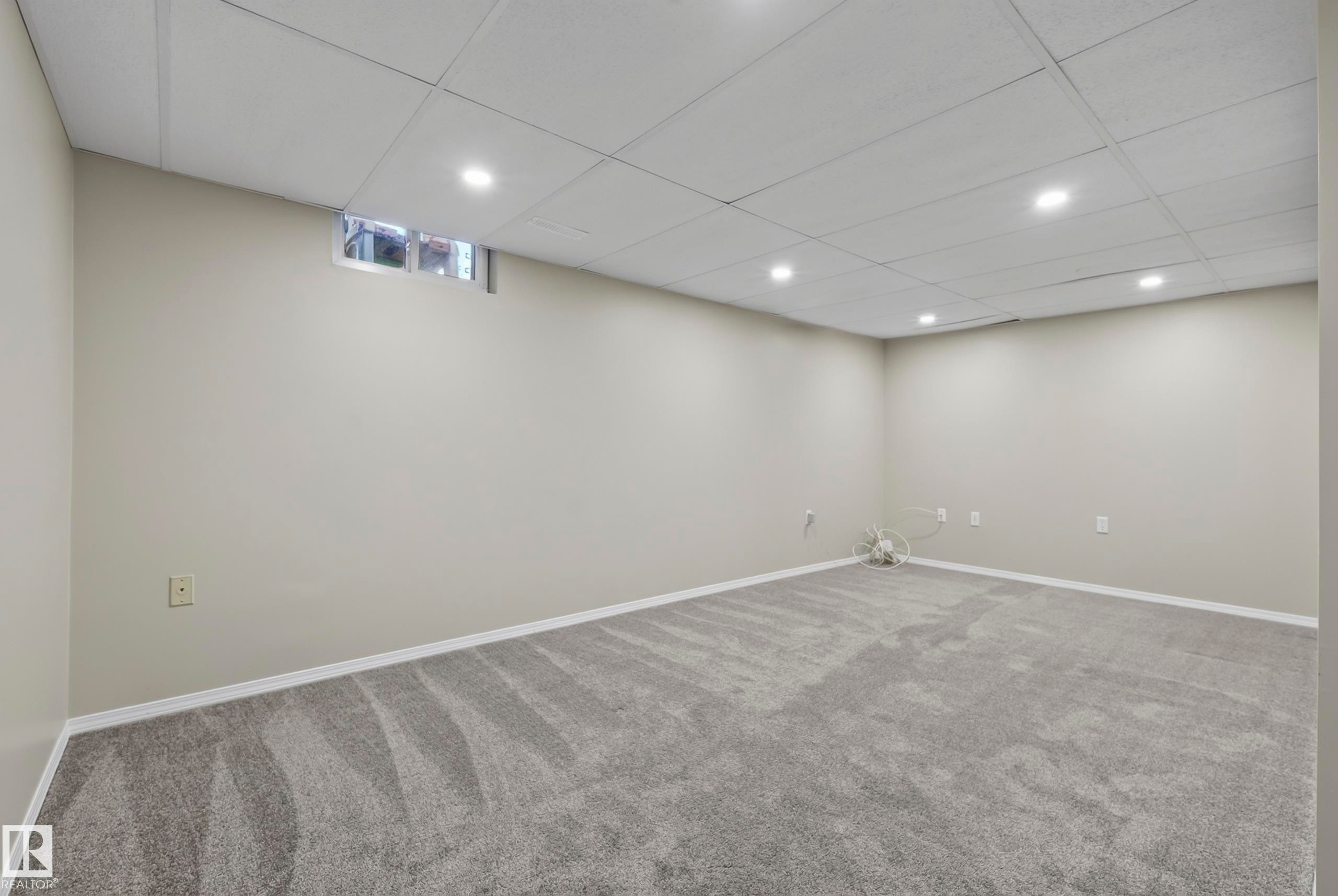 Recessed lighting, drop ceiling, neutral wall paint, gray carpeting, and a small transom window - 141 Dickinsfield Court Nw, Edmonton, AB