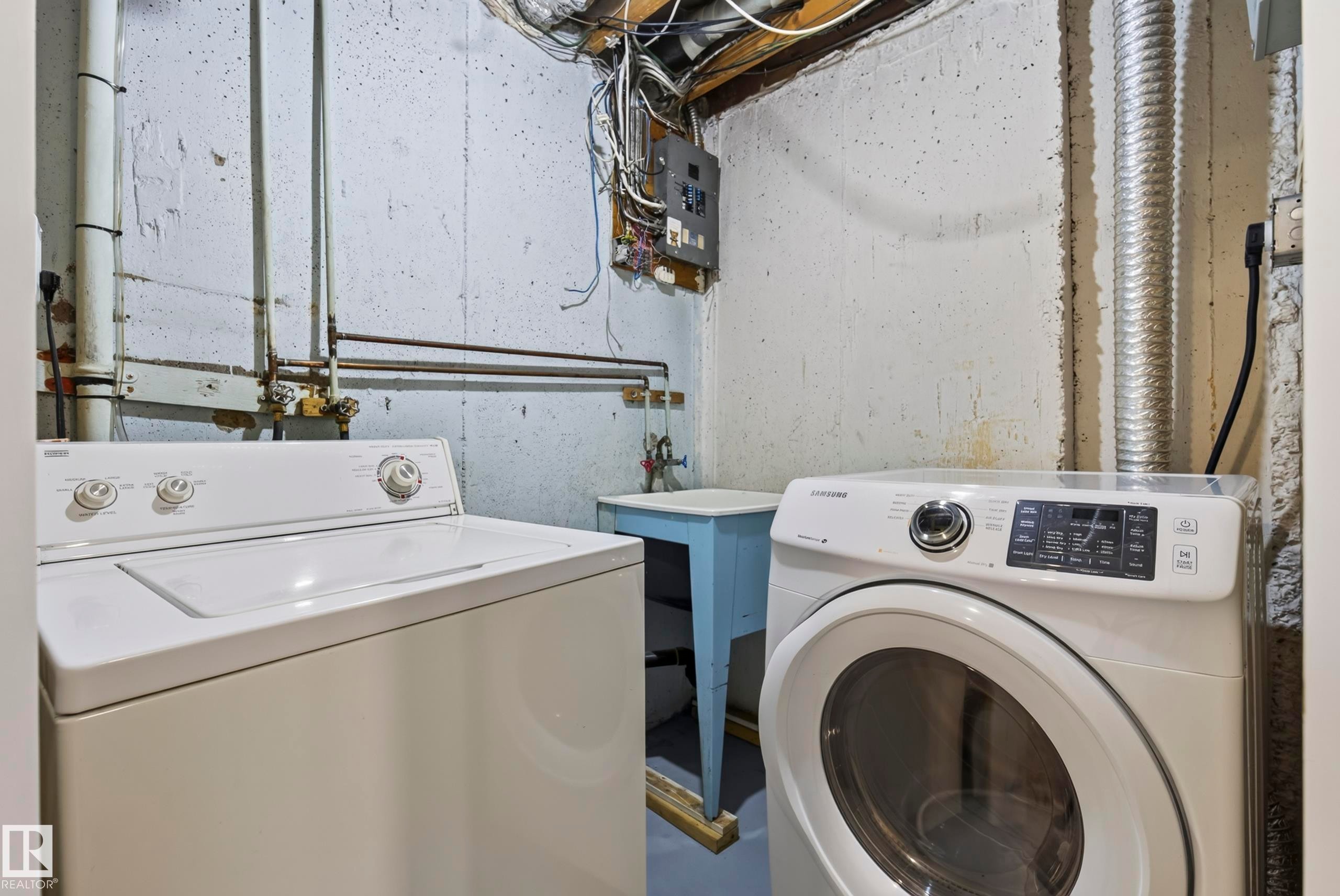 Laundry area with a utility sink, exposed piping, and concrete walls - 141 Dickinsfield Court Nw, Edmonton, AB