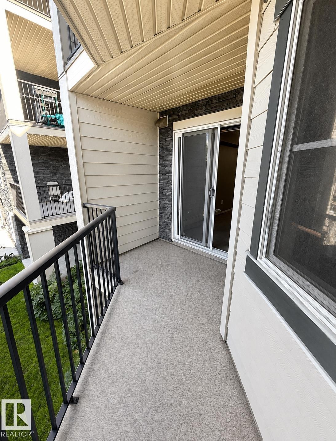 Private balcony with a sliding glass door and black metal railing - #208 18122 77 St Nw, Edmonton, AB
