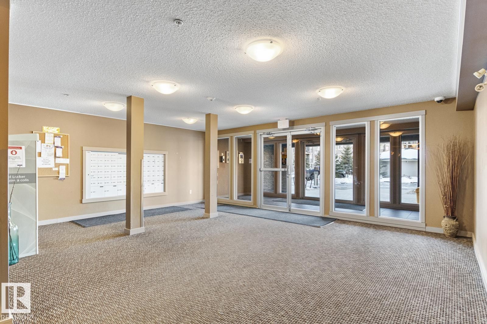 Entry foyer featuring carpet flooring and multiple flush-mount ceiling lights - #208 18122 77 St Nw, Edmonton, AB