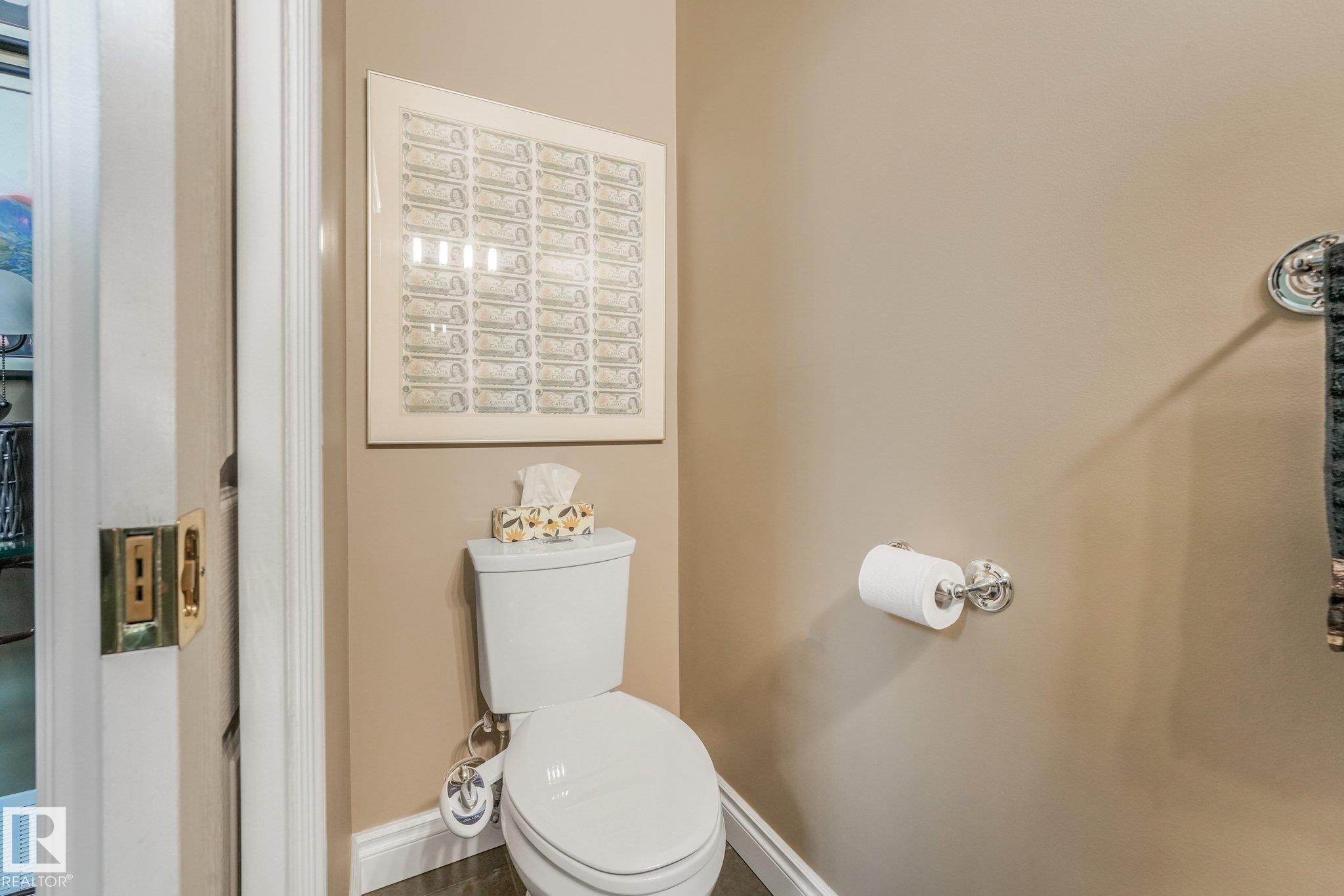 White toilet with chrome hardware - 10531 137 Street Nw, Edmonton, AB