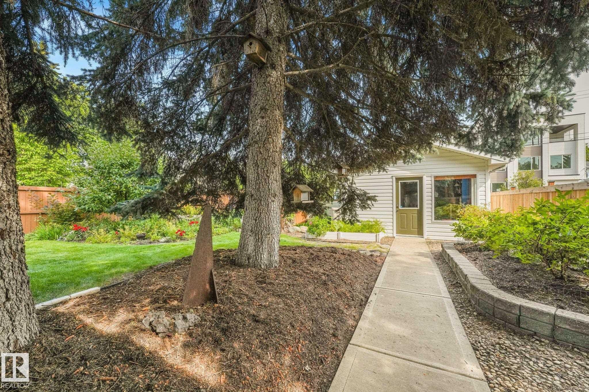 Detached double garage with work area, concrete pathway, and a wood privacy fence - 10531 137 Street Nw, Edmonton, AB