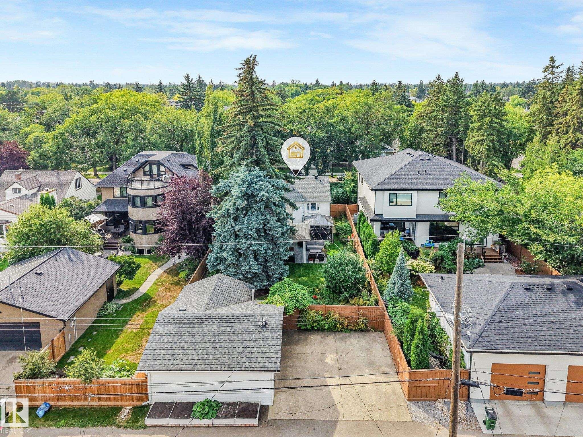 Expansive lot with mature trees and established landscaping, detached garage with paved driveway, and private fenced yard - 10531 137 Street Nw, Edmonton, AB
