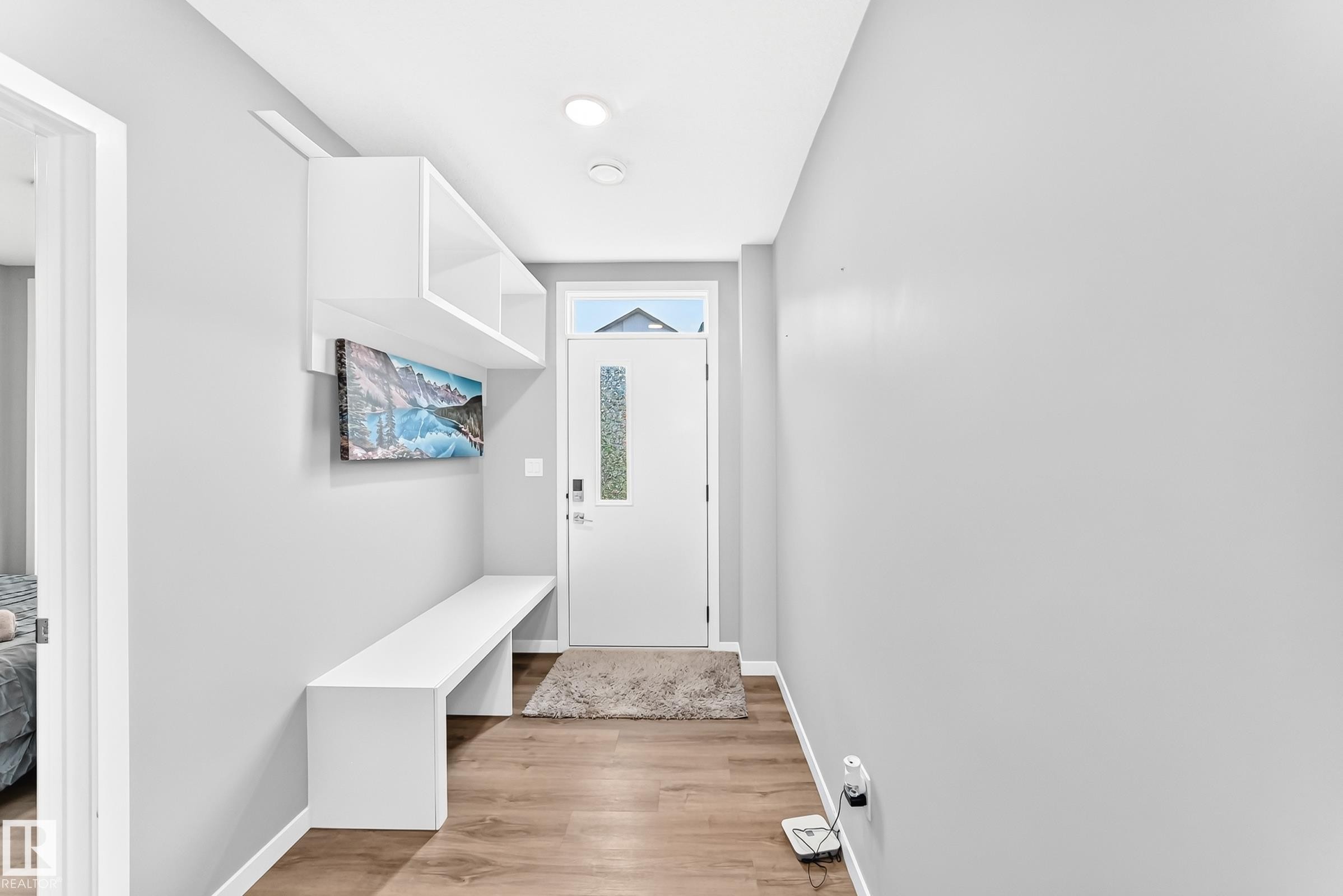 Entryway with wood-finish flooring, built-in shelving, integrated bench seating, and recessed lighting - 479 39 St Sw, Edmonton, AB