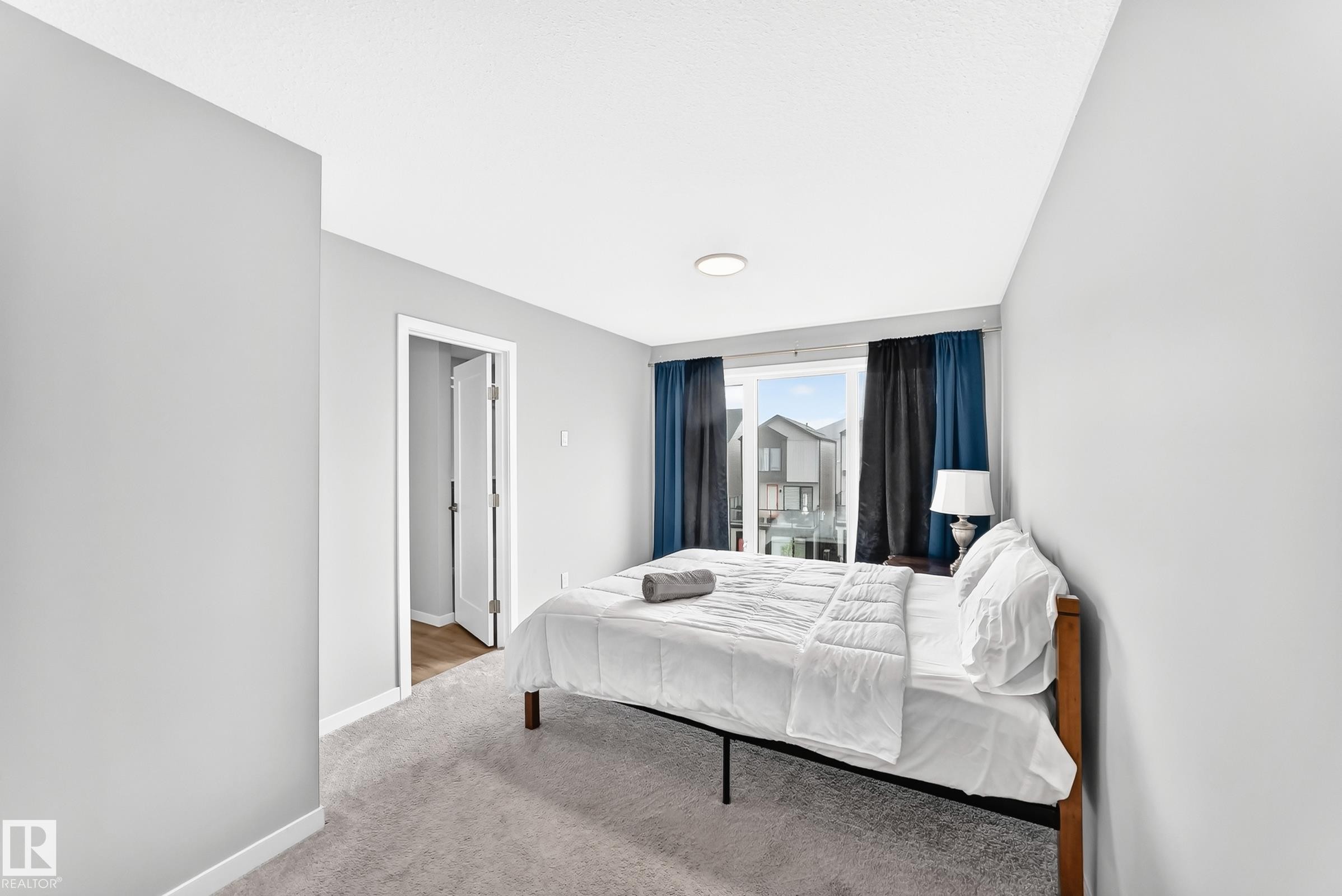 Recessed ceiling light, light gray wall paint, gray carpeting, white trim, sliding glass door - 479 39 St Sw, Edmonton, AB