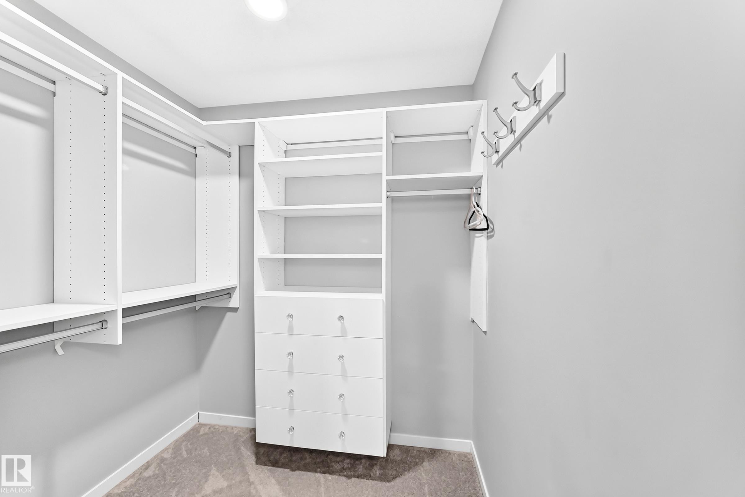 Custom closet organization system with integrated drawers, shelving, and hanging rods - 479 39 St Sw, Edmonton, AB