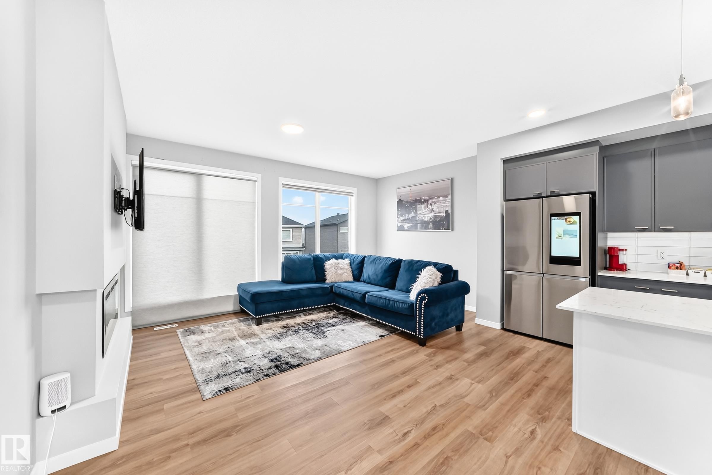 Open-concept living space featuring wood-finish flooring, recessed lighting, and a built-in fireplace - 479 39 St Sw, Edmonton, AB