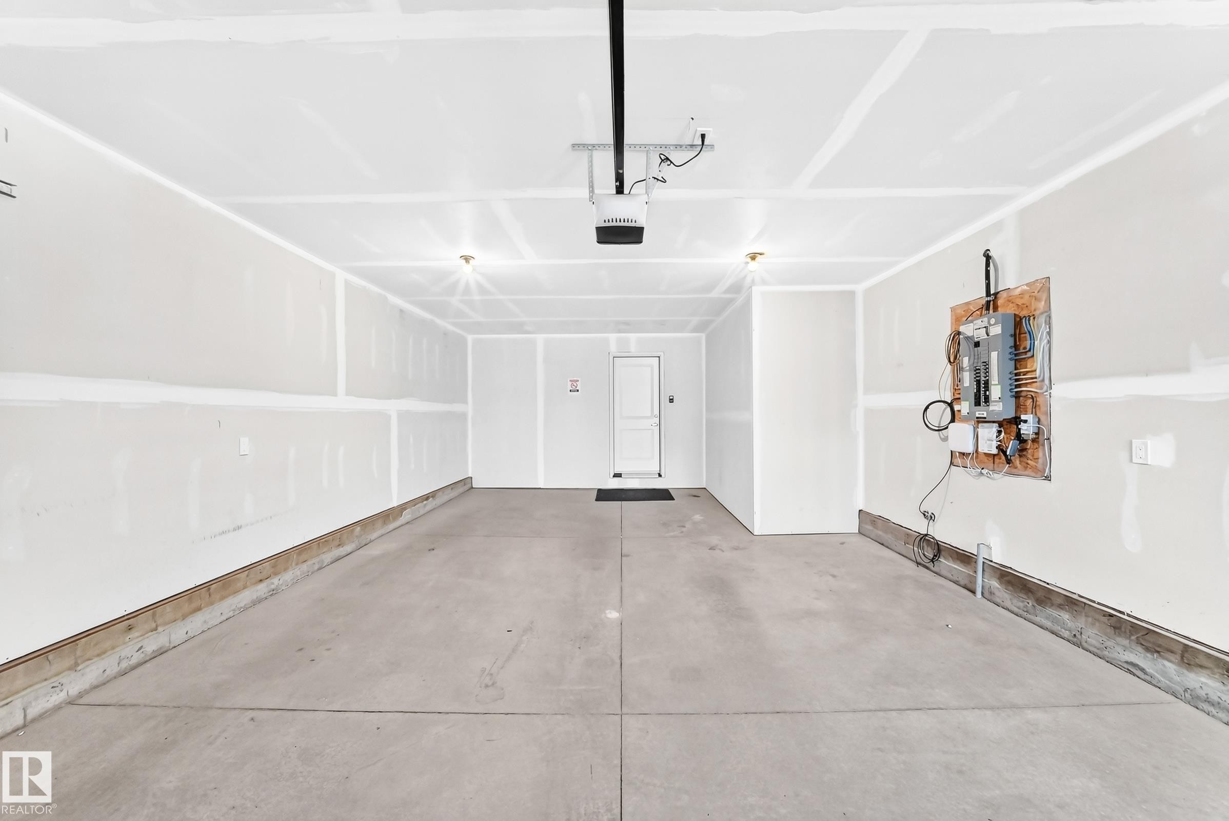 Concrete flooring, overhead lighting, garage door opener, interior access door, exposed electrical panel - 479 39 St Sw, Edmonton, AB