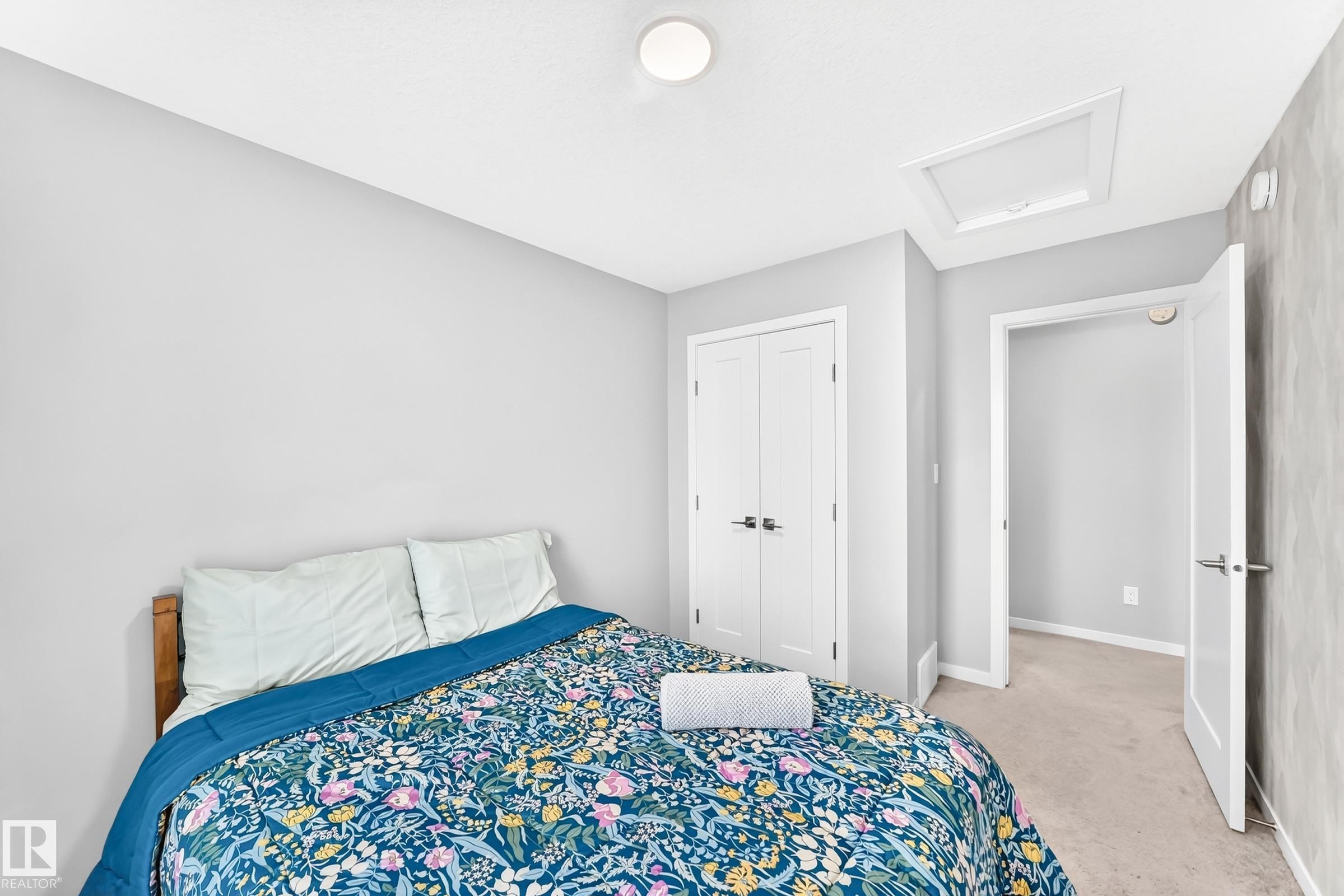Recessed lighting, wood-finish bed frame, light gray wall paint, white trim, and a white interior door - 479 39 St Sw, Edmonton, AB