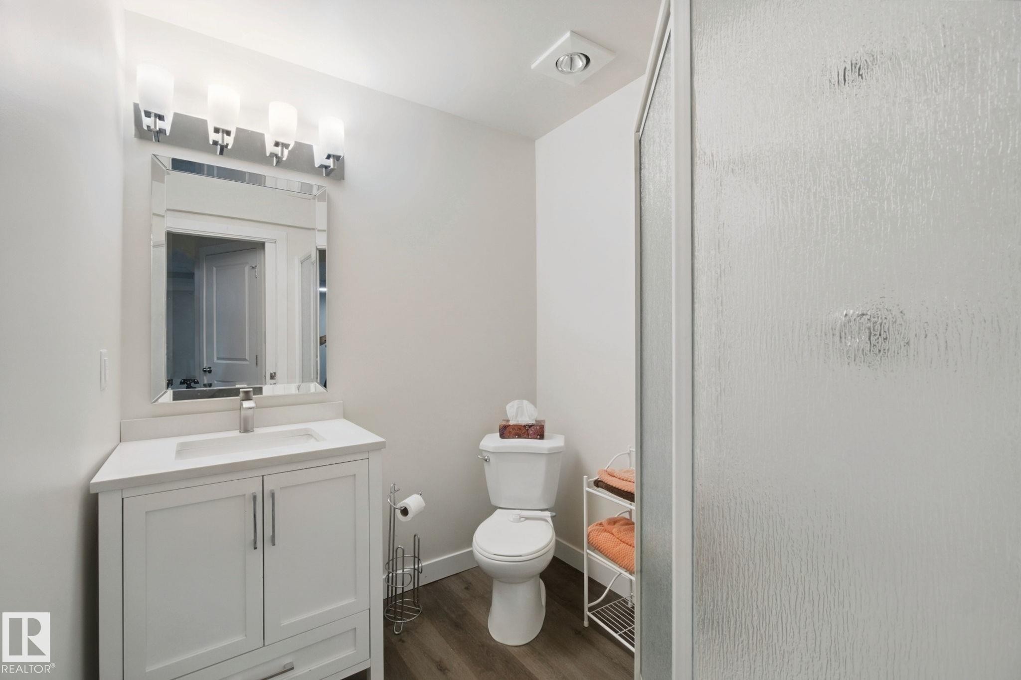 White vanity with brushed nickel hardware, a rectangular undermount sink, and a white countertop - 15618 141 Street Nw, Edmonton, AB