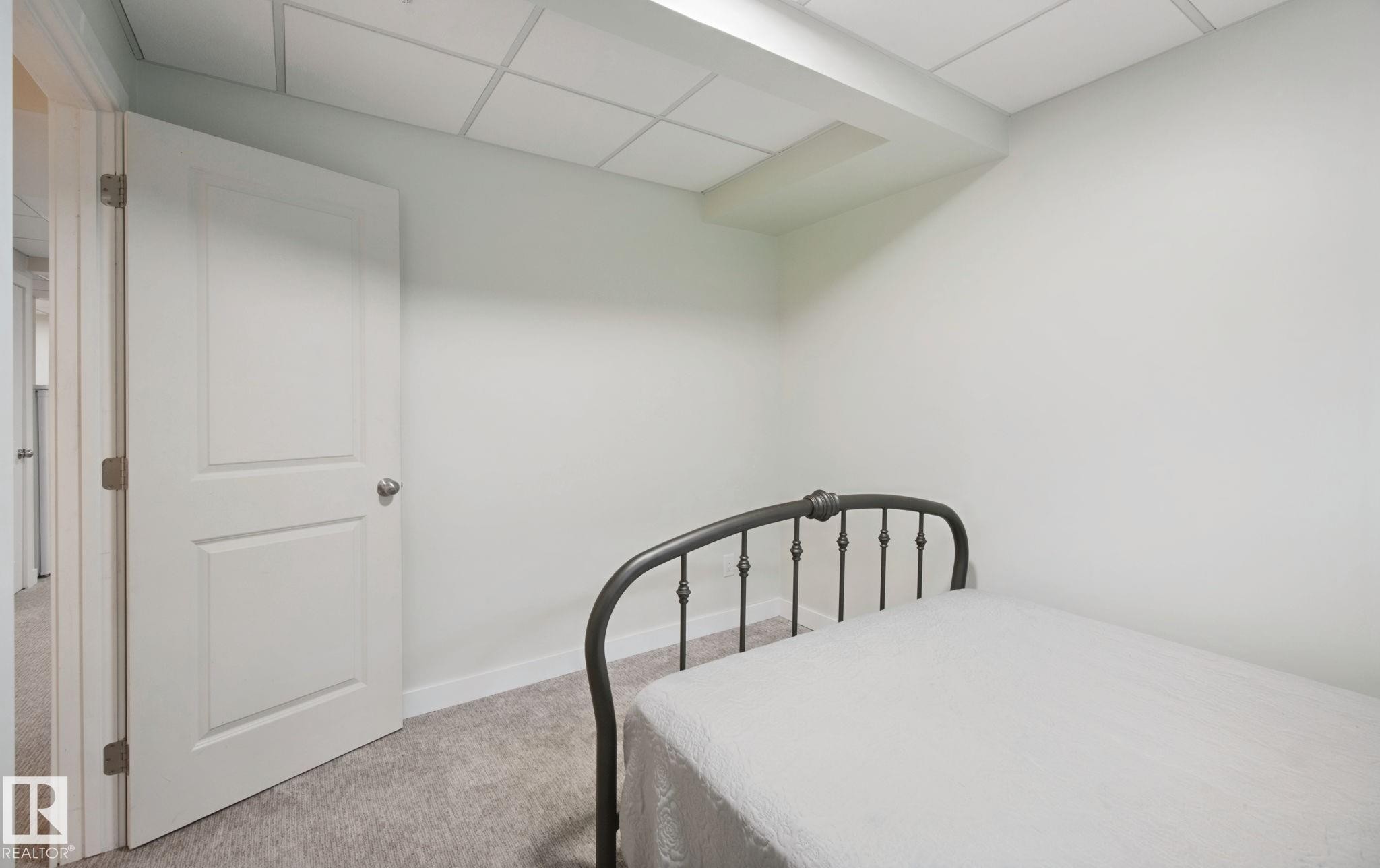 Wall-to-wall carpeting with light-toned walls and a paneled door - 15618 141 Street Nw, Edmonton, AB