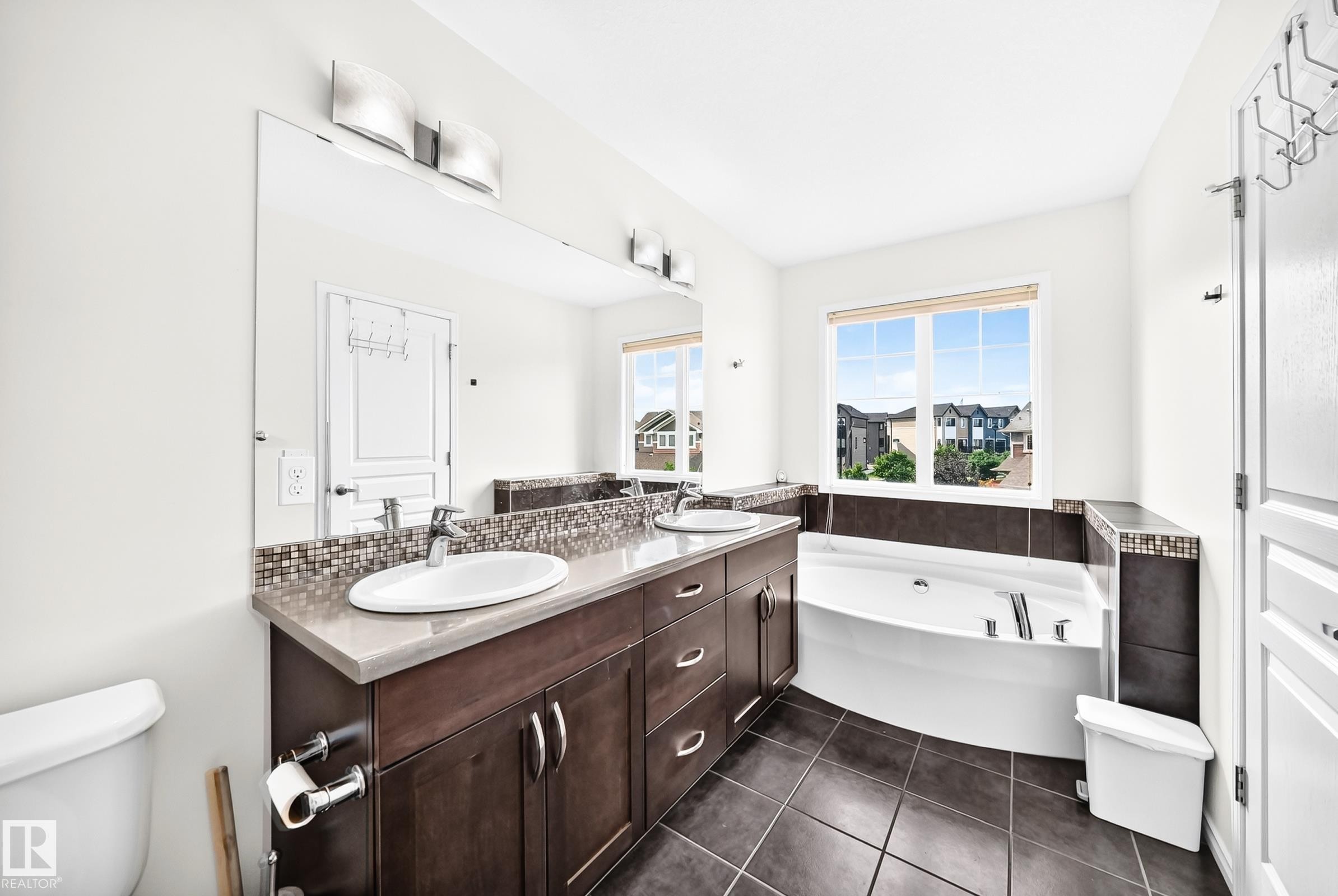 Dual vanity with undermount sinks, mosaic tile backsplash, and dark wood-finish cabinetry - 2015 Chalmers Way Sw, Edmonton, AB