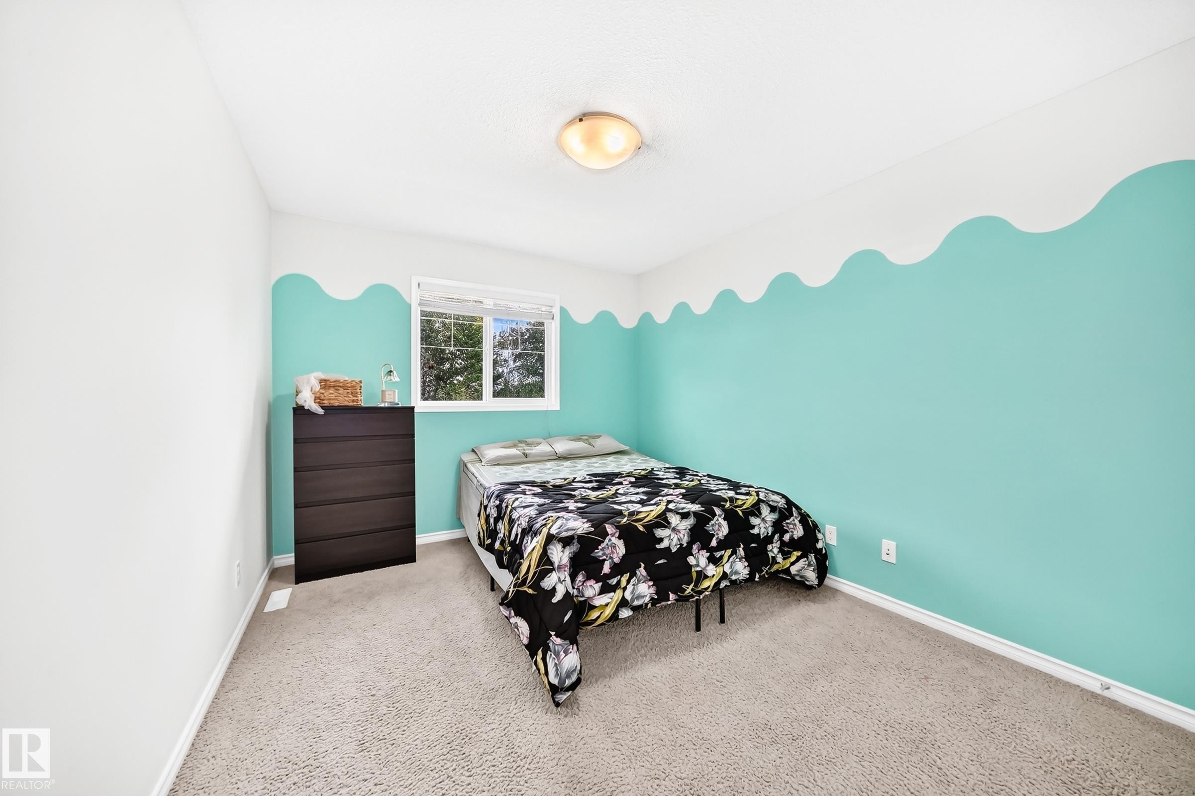Plush carpet flooring, a window offering natural light, and a ceiling-mounted light fixture - 2015 Chalmers Way Sw, Edmonton, AB