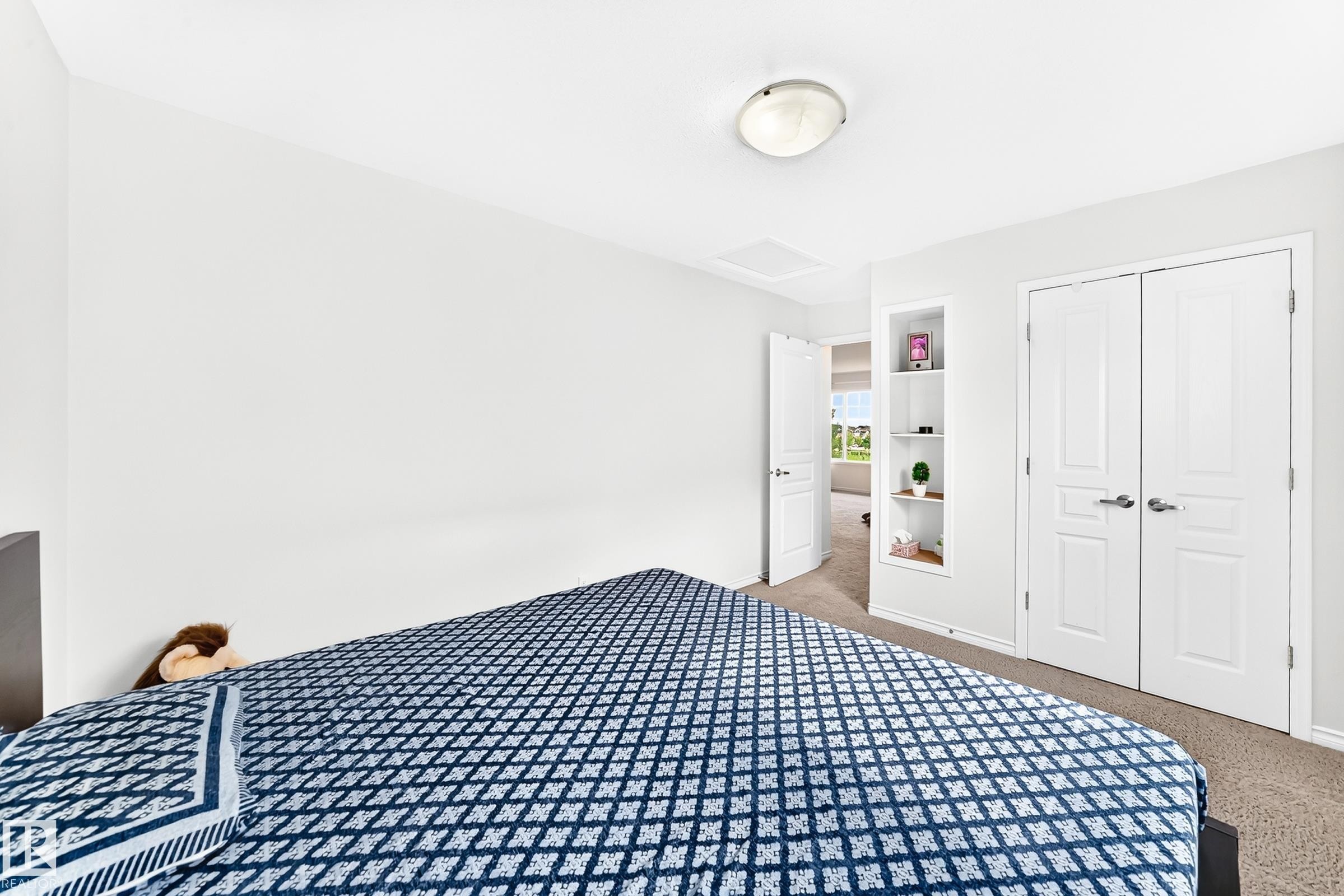 Recessed built-in shelving, white paneled doors, and a ceiling-mounted light fixture - 2015 Chalmers Way Sw, Edmonton, AB