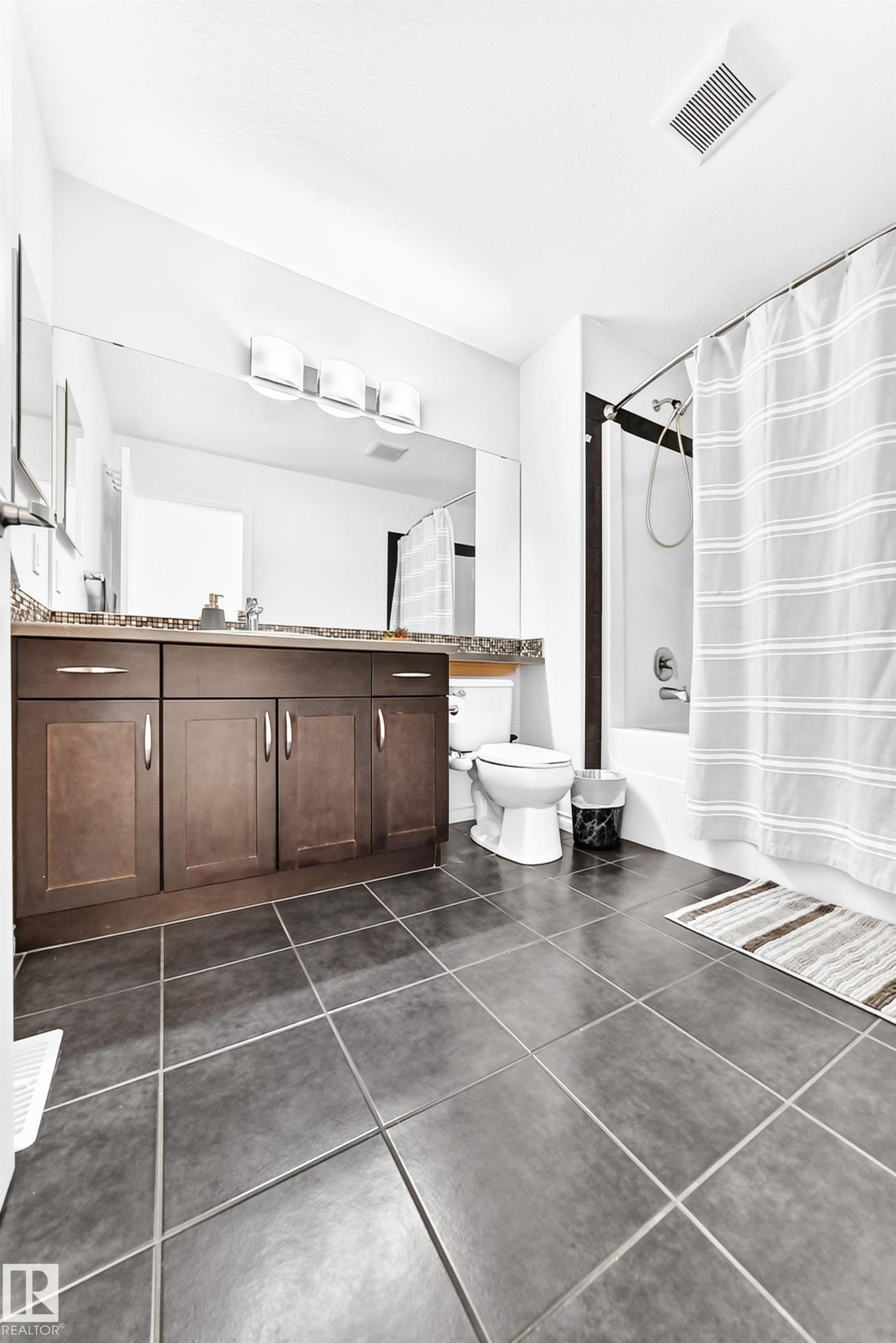 Dark wood-finish vanity with drawer and cabinet storage, stone-look countertop, and integrated sink - 2015 Chalmers Way Sw, Edmonton, AB