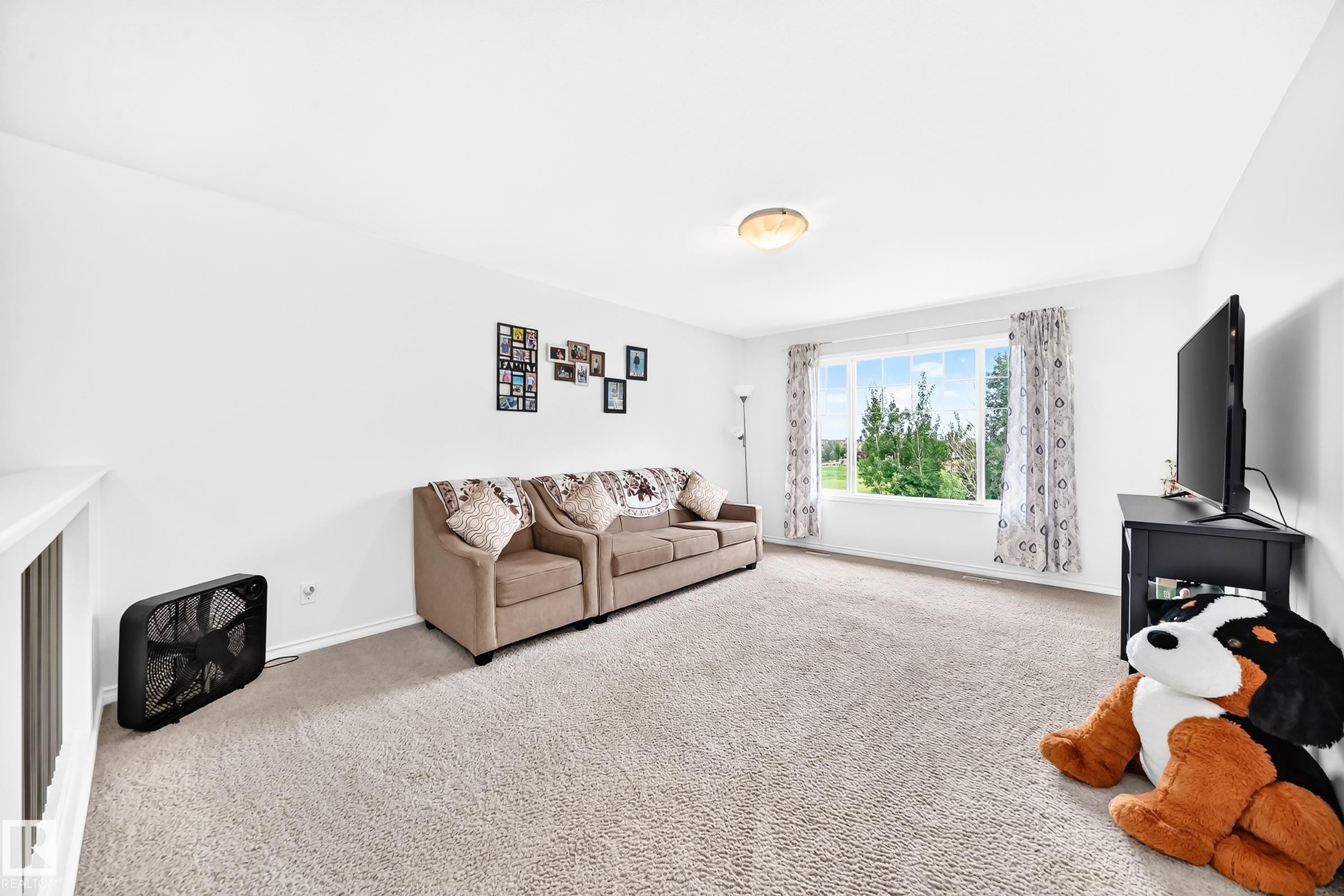 Recessed ceiling light fixture, white painted walls, large window with outdoor scenery, light-colored carpet flooring, white trim - 2015 Chalmers Way Sw, Edmonton, AB