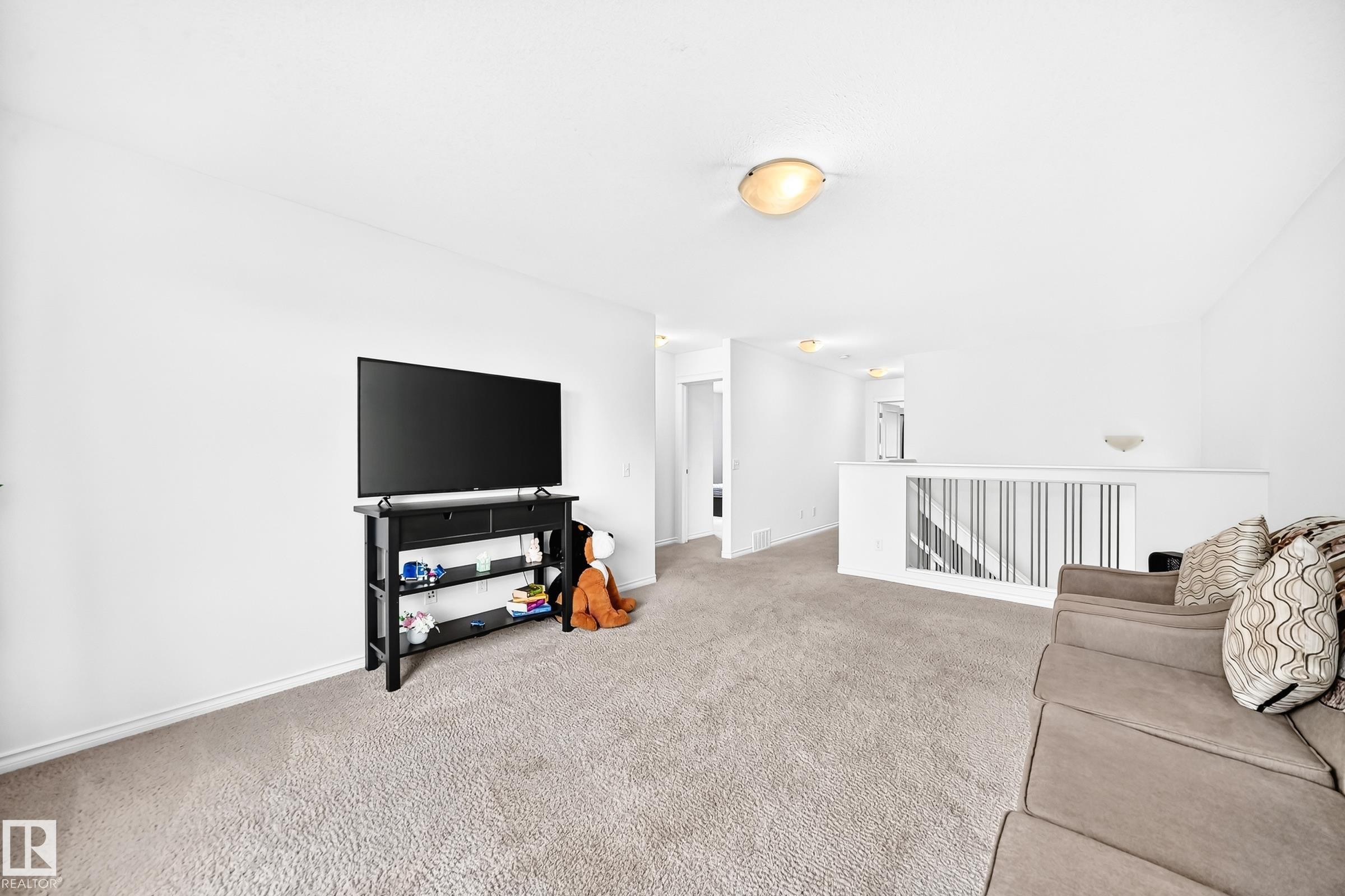 Light-colored carpeting throughout, white wall finishes, and a contemporary railing design - 2015 Chalmers Way Sw, Edmonton, AB