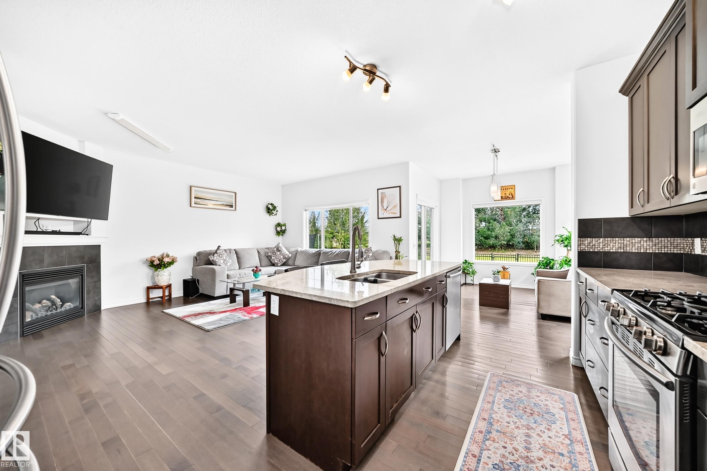 Open-concept living area featuring wood-finish flooring - 2015 Chalmers Way Sw, Edmonton, AB
