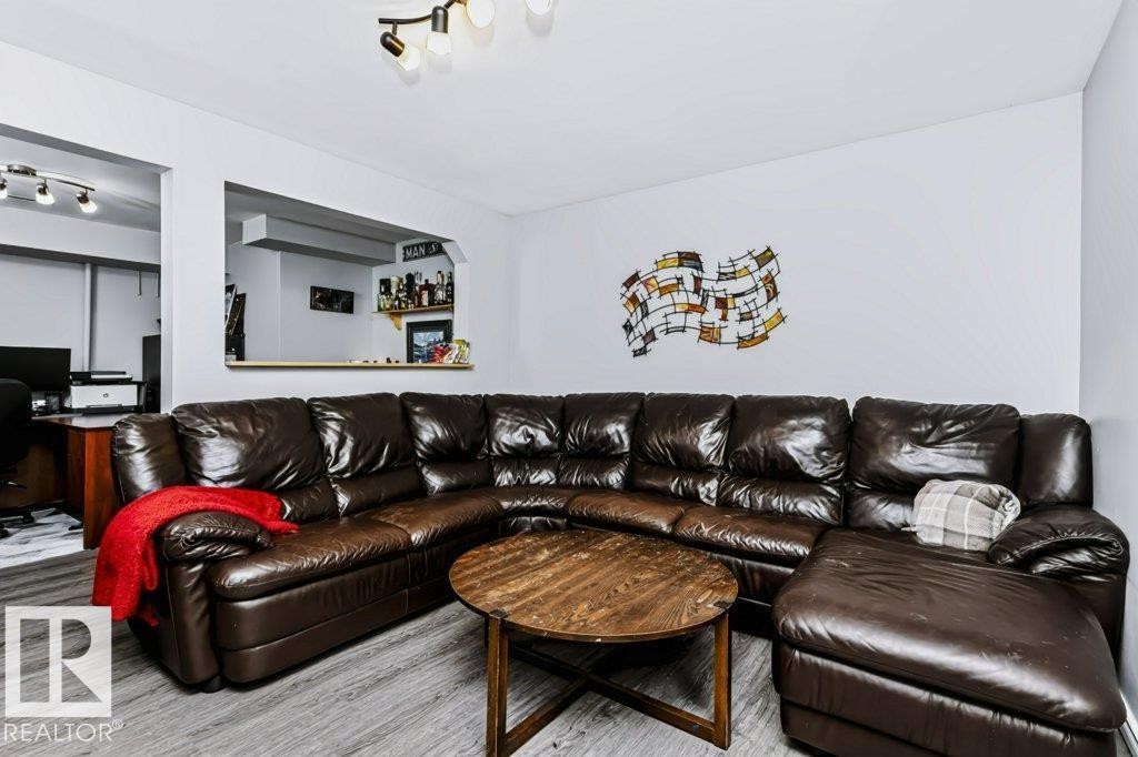 Wood-finish flooring throughout, a pass-through window with a built-in shelf, and track lighting fixtures - 18431 95A Avenue Nw, Edmonton, AB