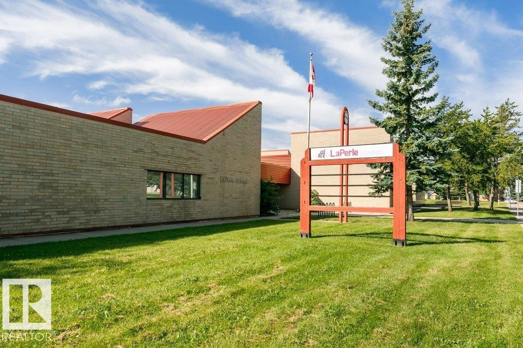 Brick exterior with a red metal roof and multiple windows - 18431 95A Avenue Nw, Edmonton, AB