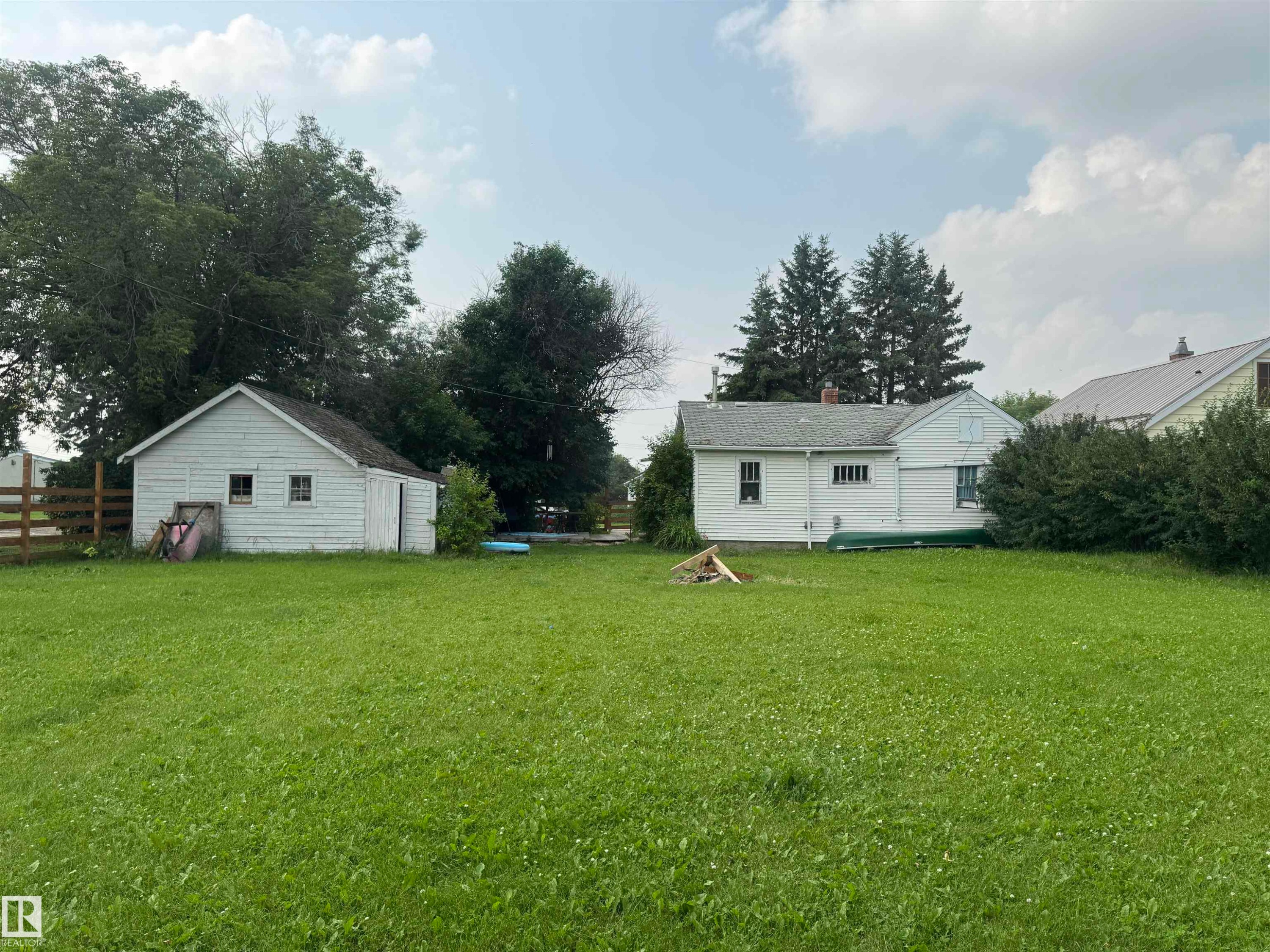 Expansive green lawn with a detached white 15'x20'. garage. featuring dual windows and a side entry - 5019 48 Avenue, Onoway, AB - Outdoor