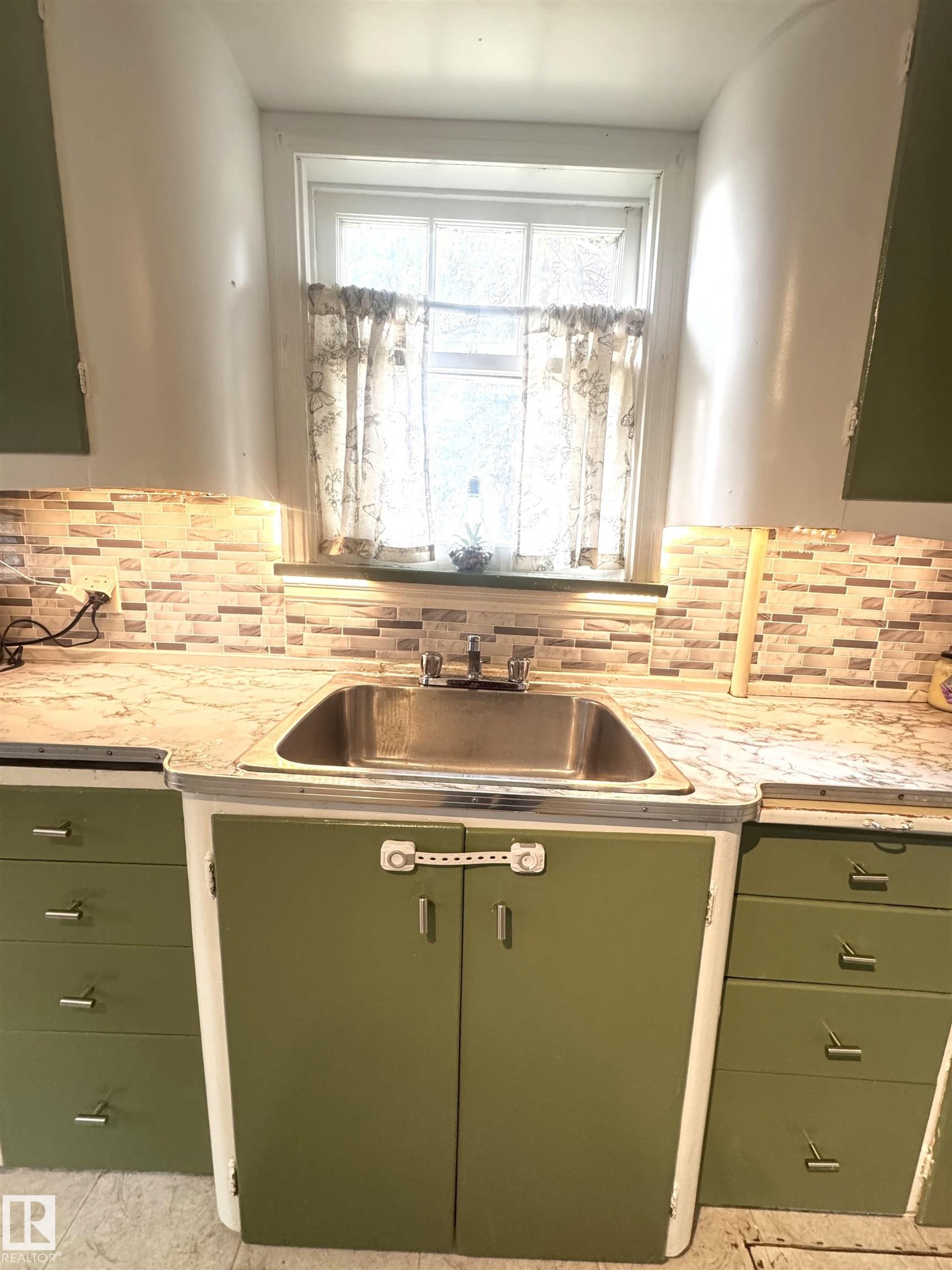 Stainless steel kitchen sink with a chrome faucet and under-cabinet lighting - 5019 48 Avenue, Onoway, AB - Indoor Photo Showing Kitchen