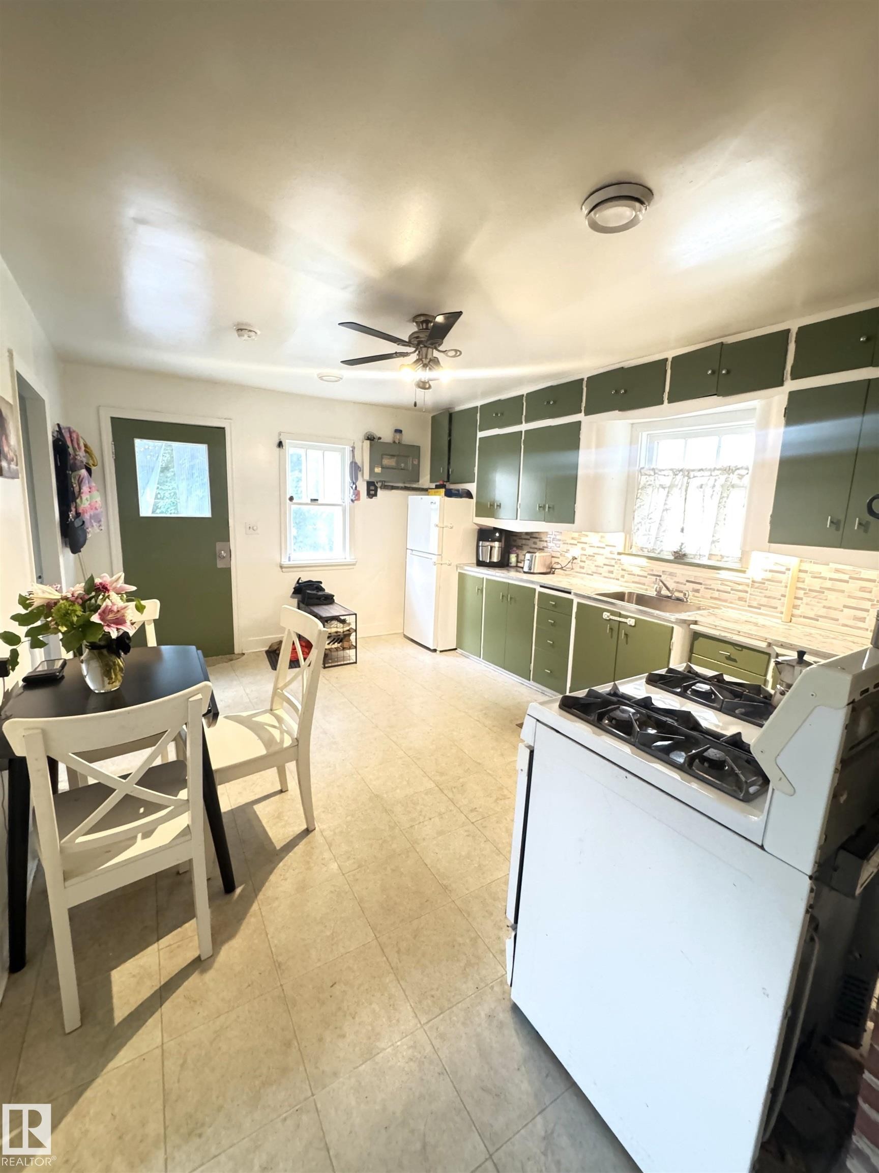 Kitchen featuring green cabinetry, tile flooring, and white appliances - 5019 48 Avenue, Onoway, AB - Indoor