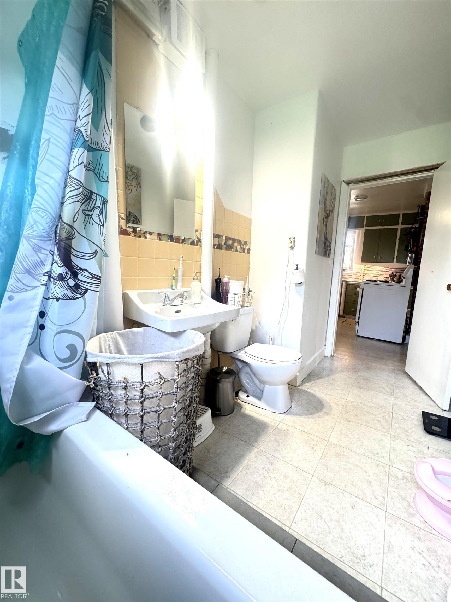 Bathroom featuring a pedestal sink, toilet, and a bathtub with a shower - 5019 48 Avenue, Onoway, AB - Indoor Photo Showing Bathroom