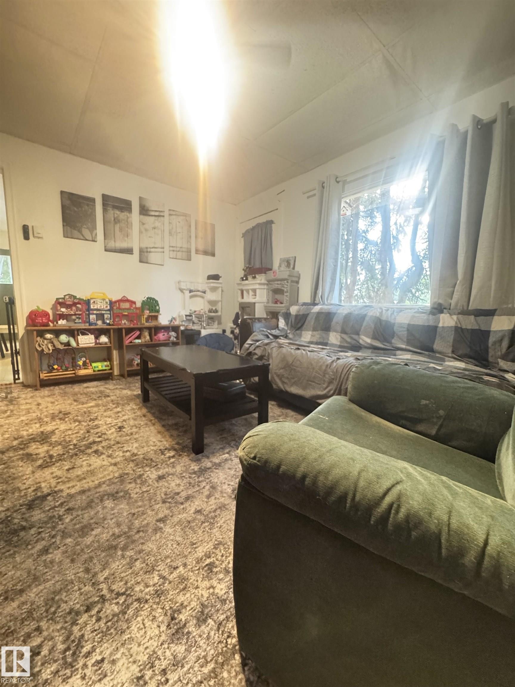 living room features hard wood floor and picture window - 5019 48 Avenue, Onoway, AB - Indoor