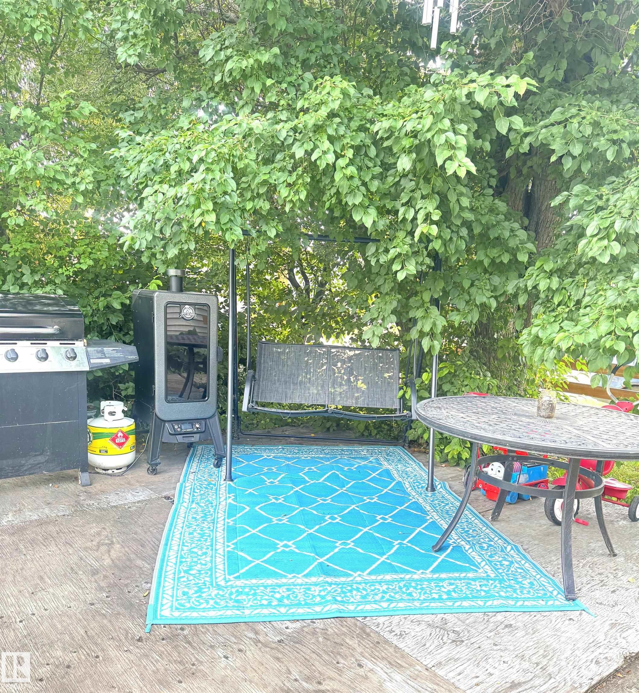 Expansive outdoor space featuring a patio base with mature tree canopy - 5019 48 Avenue, Onoway, AB - Outdoor