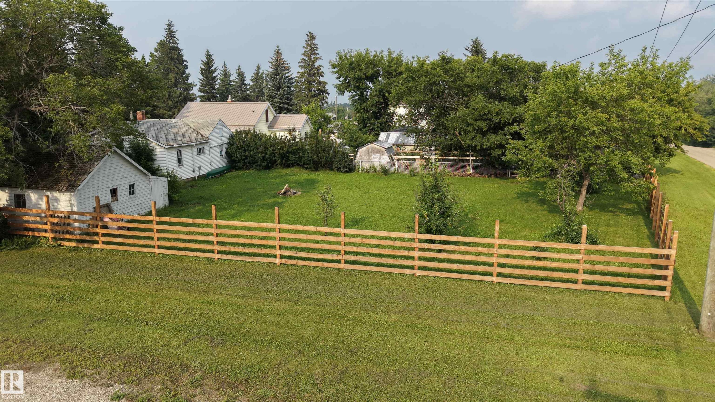 Expansive back yard featuring a new split-rail fence, house and garage. - 5019 48 Avenue, Onoway, AB - Outdoor