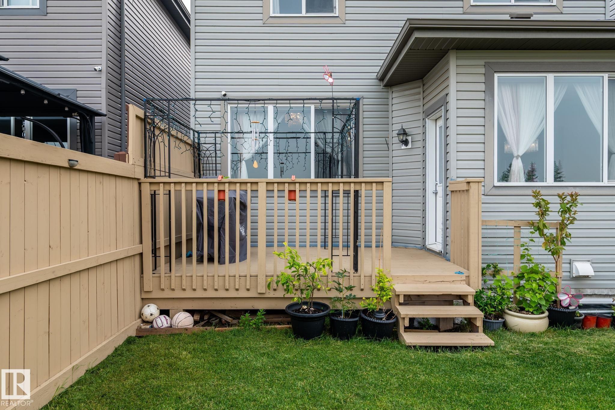 Expansive wood deck with stairs leading to a manicured lawn - 2131 51 Sw, Edmonton, AB - Outdoor With Exterior