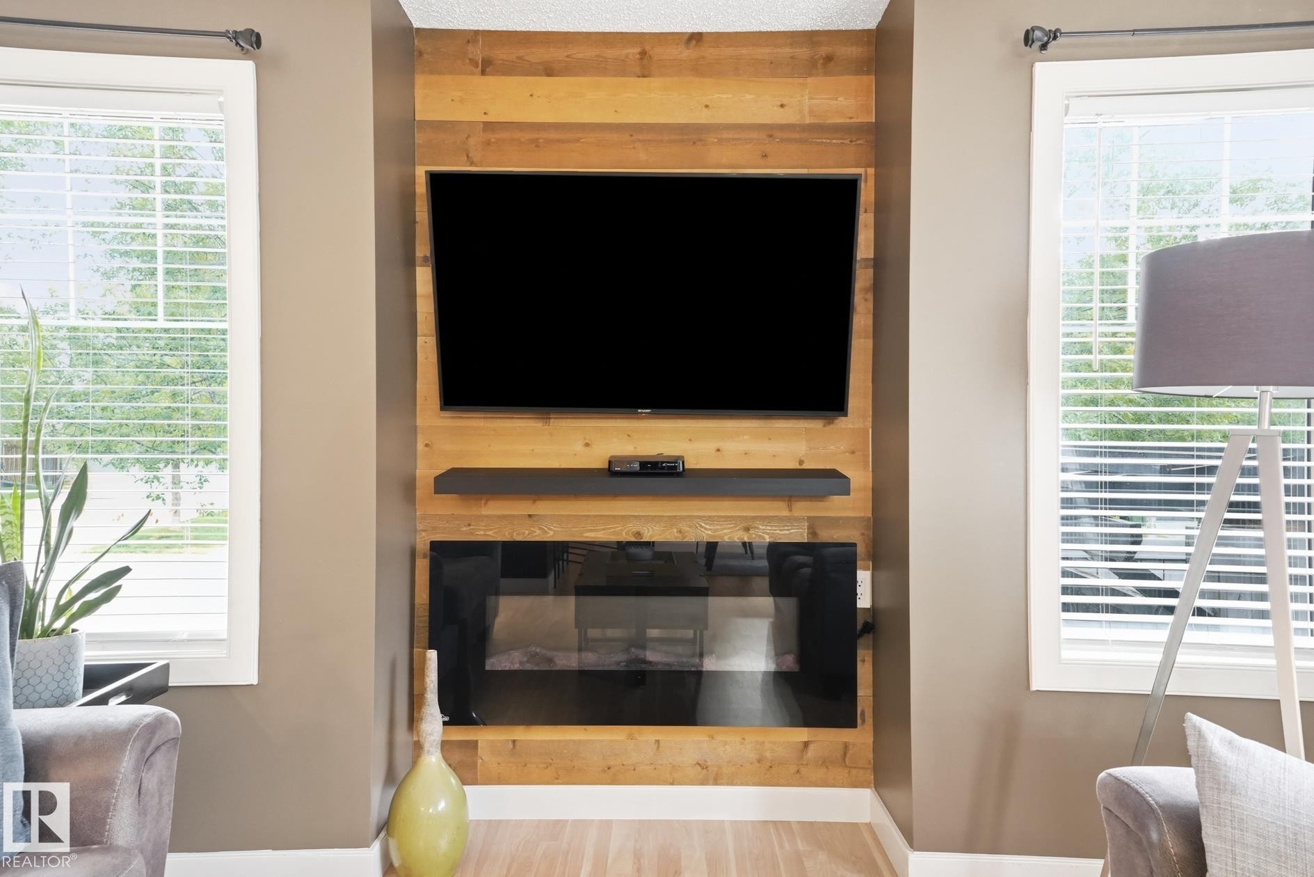 Reclaimed wood-finish accent wall with a built-in electric fireplace and a floating shelf - 20007 131 Avenue Nw, Edmonton, AB