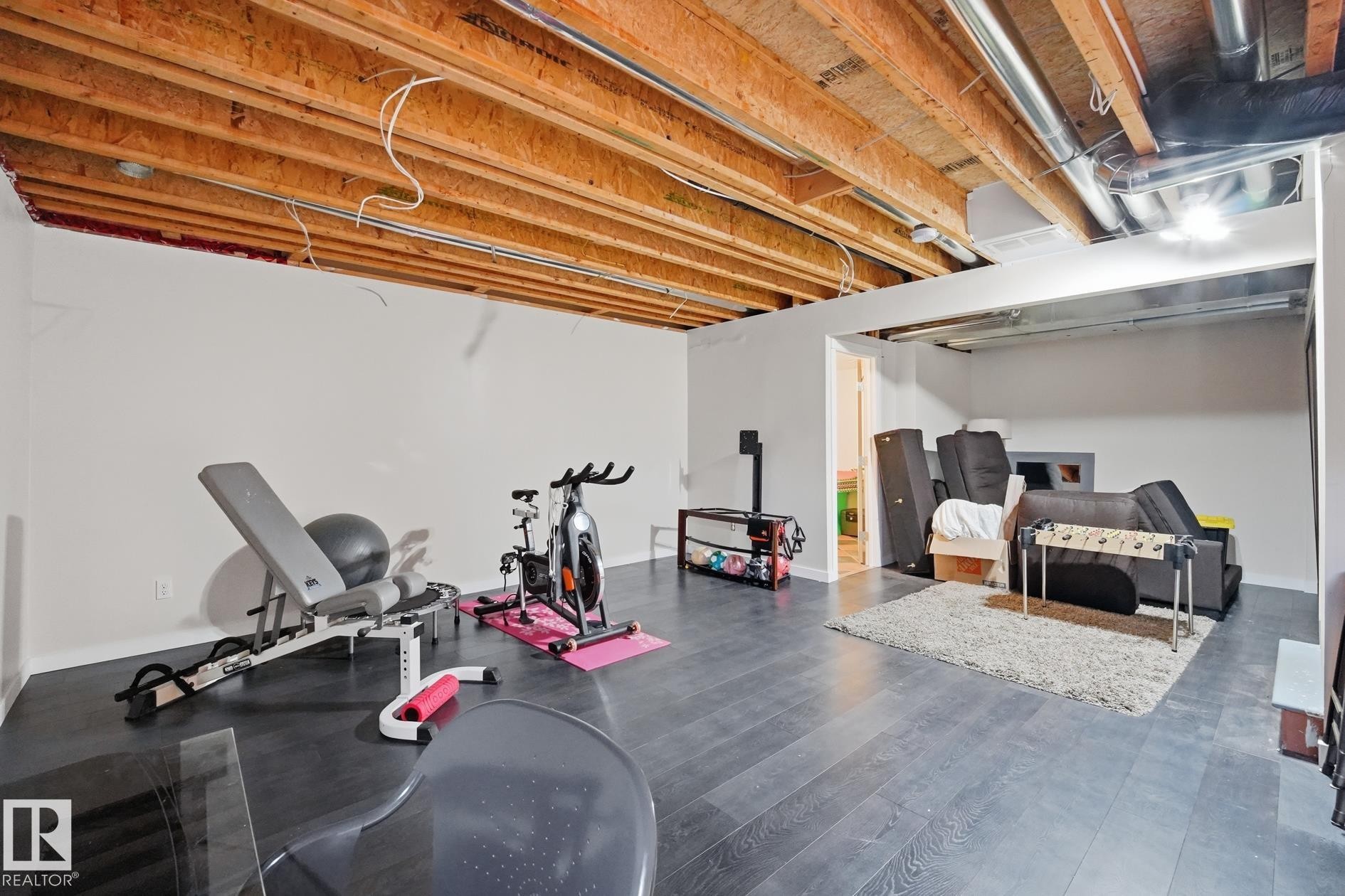 Finished white walls, wood-finish flooring, exposed ceiling joists, and recessed lighting - 20007 131 Avenue Nw, Edmonton, AB
