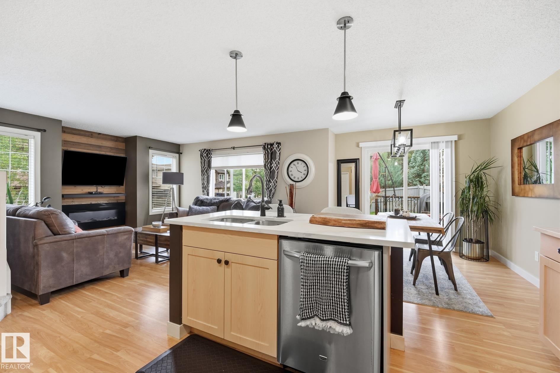 Wood-finish flooring throughout, kitchen island with built-in dishwasher, and stainless steel sink - 20007 131 Avenue Nw, Edmonton, AB