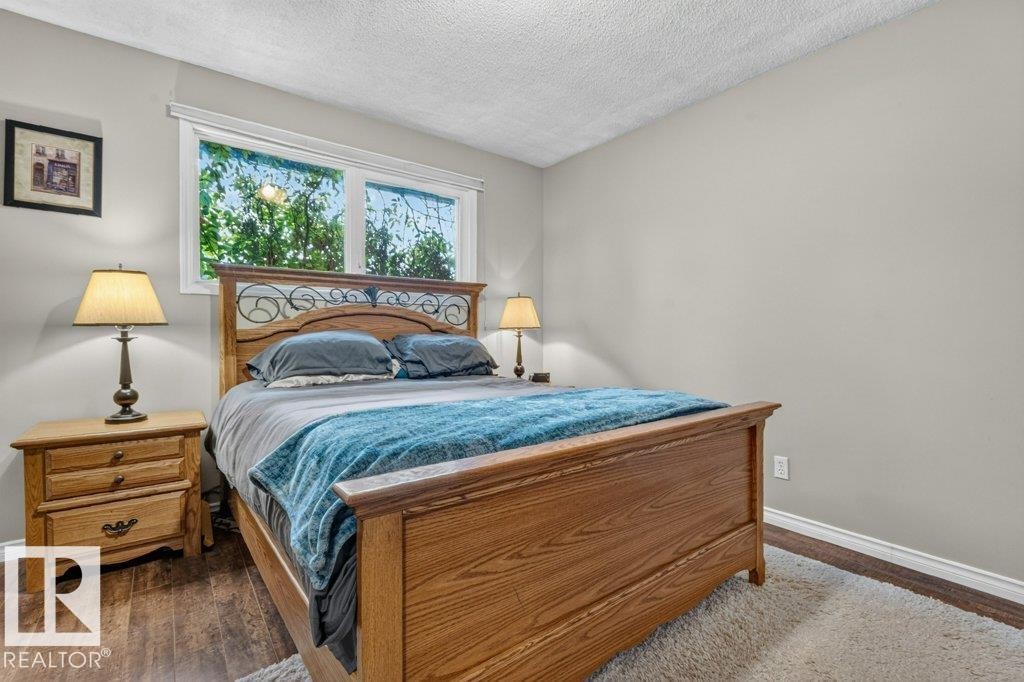 Bedroom featuring wood-finish flooring, a double window, and light gray painted walls - 11131 35A Avenue Nw, Edmonton, AB - Indoor Photo Showing Bedroom