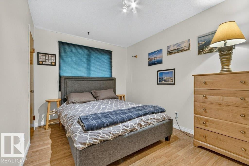 Bedroom featuring wood-finish flooring, a window with blinds, and recessed lighting - 11131 35A Avenue Nw, Edmonton, AB - Indoor Photo Showing Bedroom