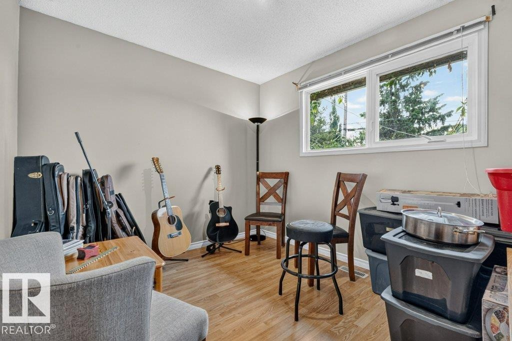 Bright room with wood-finish flooring, light-toned walls, and a large window - 11131 35A Avenue Nw, Edmonton, AB - Indoor