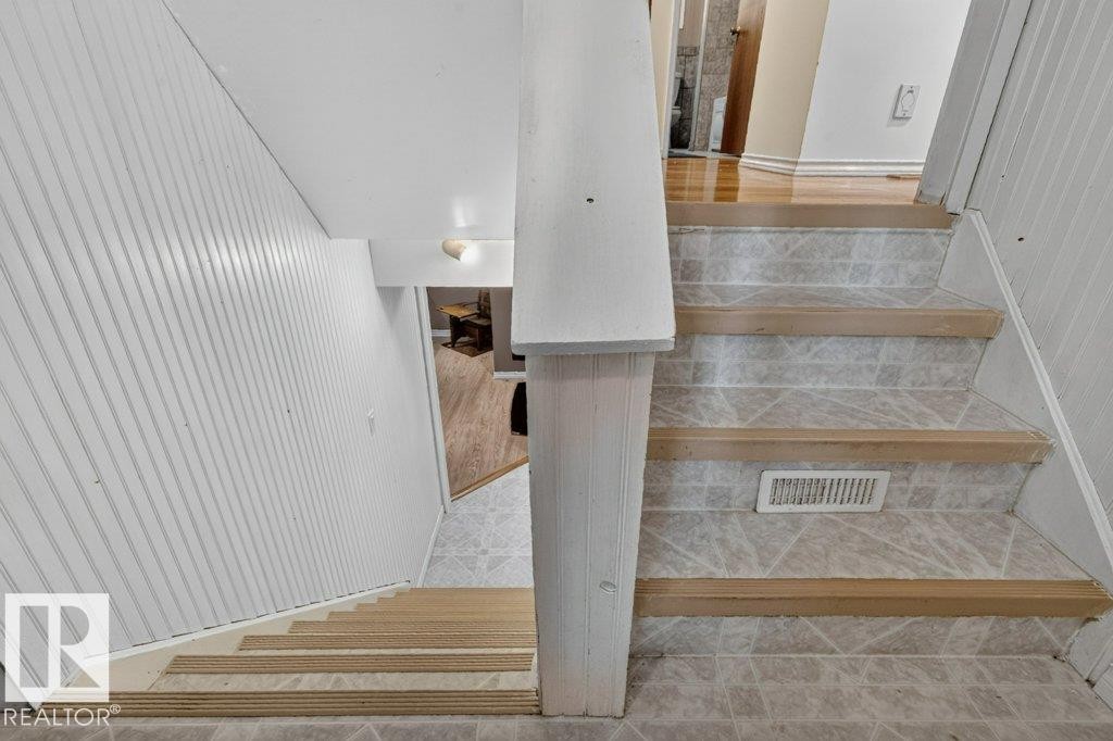 Staircase featuring wood-finish treads and tiled risers - 11131 35A Avenue Nw, Edmonton, AB - Indoor Photo Showing Other Room