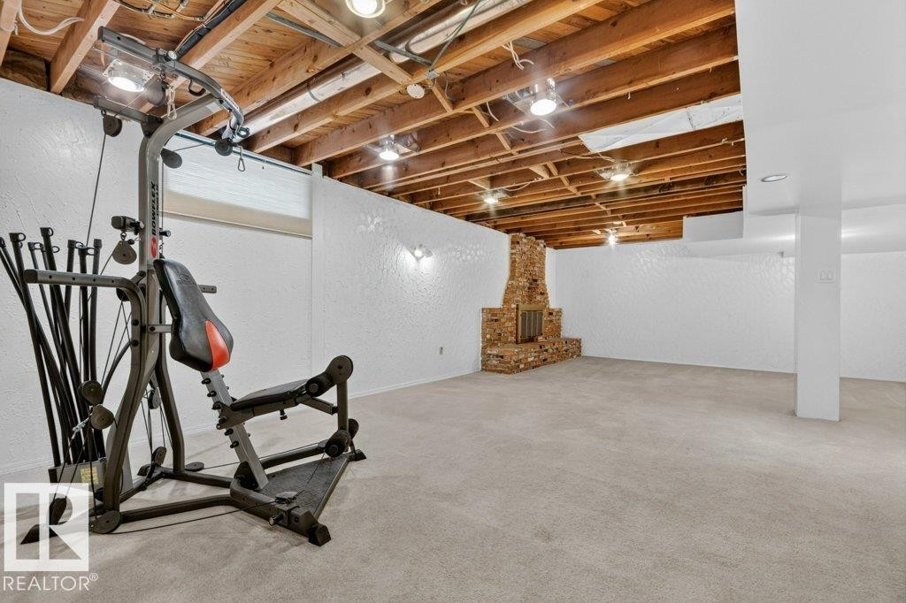 Spacious lower-level room featuring exposed wood ceiling joists with recessed lighting - 11131 35A Avenue Nw, Edmonton, AB - Indoor Photo Showing Basement