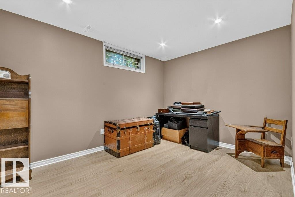 Spacious room featuring light wood-finish flooring, neutral wall paint, recessed ceiling lighting, a white window frame, and white baseboards - 11131 35A Avenue Nw, Edmonton, AB - Indoor